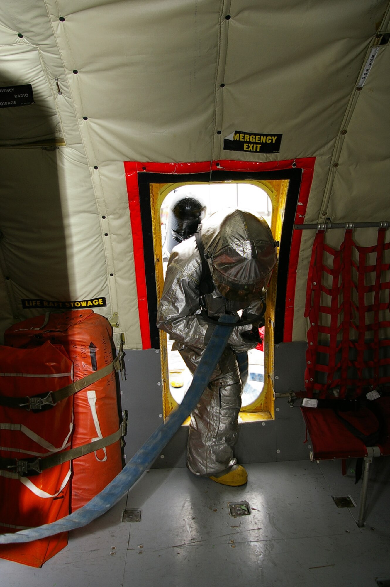 Staff Sgt. Marcus Modey, 100th Civil Engineer Fire Department, leads a team of four firefighters inside a KC-135 Stratotanker from a door above the wing, during an training exercise Nov. 13 at RAF Mildenhall. The firefighters entered the aircraft, which had a simulated engine fire, to search for "unaccounted personnel." Hands-on training is performed quarterly by the fire department, to help keep firefighters familiar with the interior layout of the aircraft and proper shut-down procedures. It also prepares them for different situations they could encounter with this type of emergency. (U.S. Air Force photo by Karen Abeyasekere)