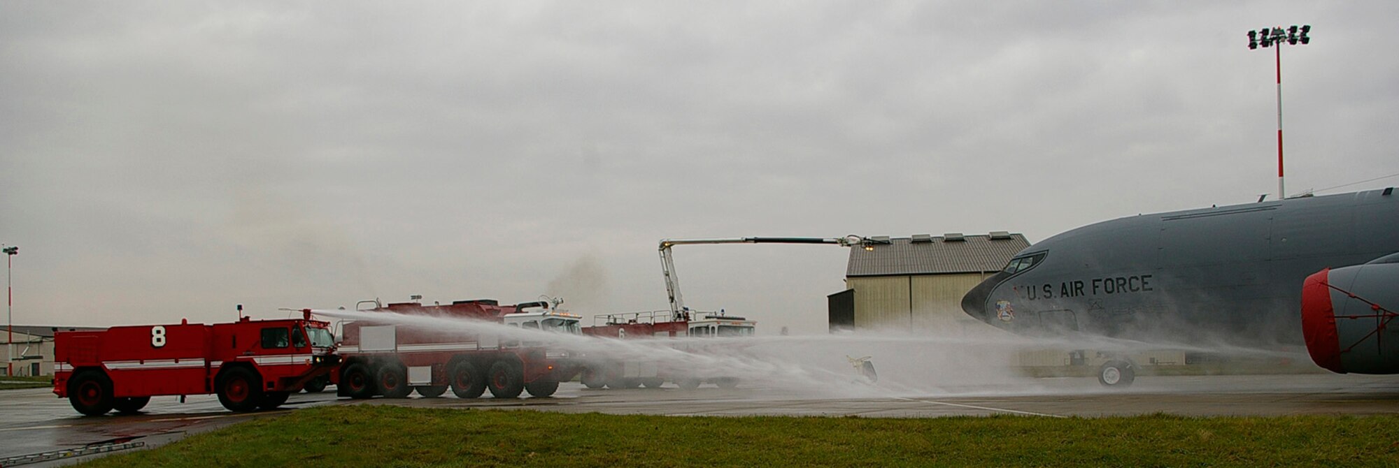 Firetrucks shoot water onto a KC-135 Nov. 13 during a training exercise simulating a fire on an aircraft engine. Six vehicles an almost 20 firefighters were involved in the exercise. (Air Force photo by Karen Abeyasekere)