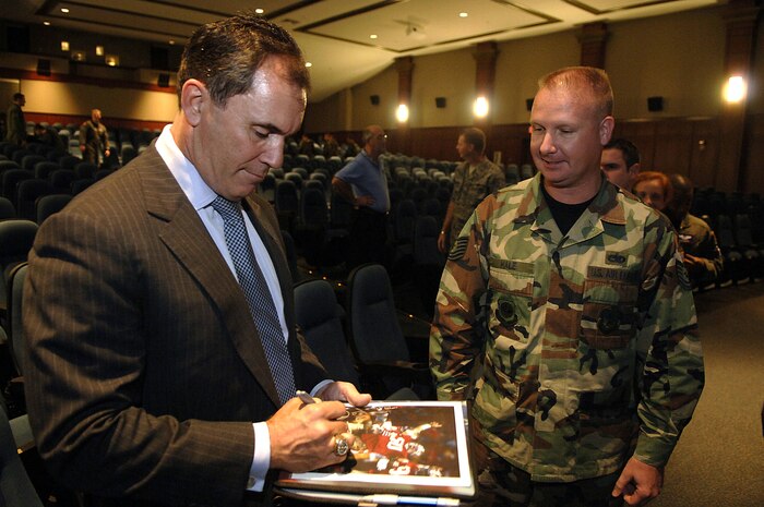 Ricky Ellison, former linebacker for the San Francisco 49ers, signs an autograph for Tech. Sgt. Eric Hale, 437th Airlift Wing Protocol Office.  Mr Ellison spoke to Airmen about professional development, his football career and missile defense systems at the Charleston Air Force Base, S.C., theater. (U.S. Air Force photo/Senior Airman Nicholas Pilch)