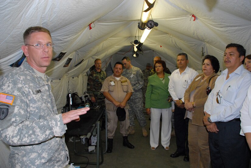 SOTO CANO AIR BASE, Honduras -- Army Maj. (Dr.) Kurt Davis, a general surgeon and Mobile Surgical Team commander, explains field medical procedures to a group of Honduran government officials during Local Leaders Day here Nov. 27.  The annual event brought together not only Honduran government leaders, but also representatives from the U.S. Embassy, World Food Program, and the U.S. Agency for International Development.  (U.S. Air Force photo/Tech. Sgt. Sonny Cohrs)