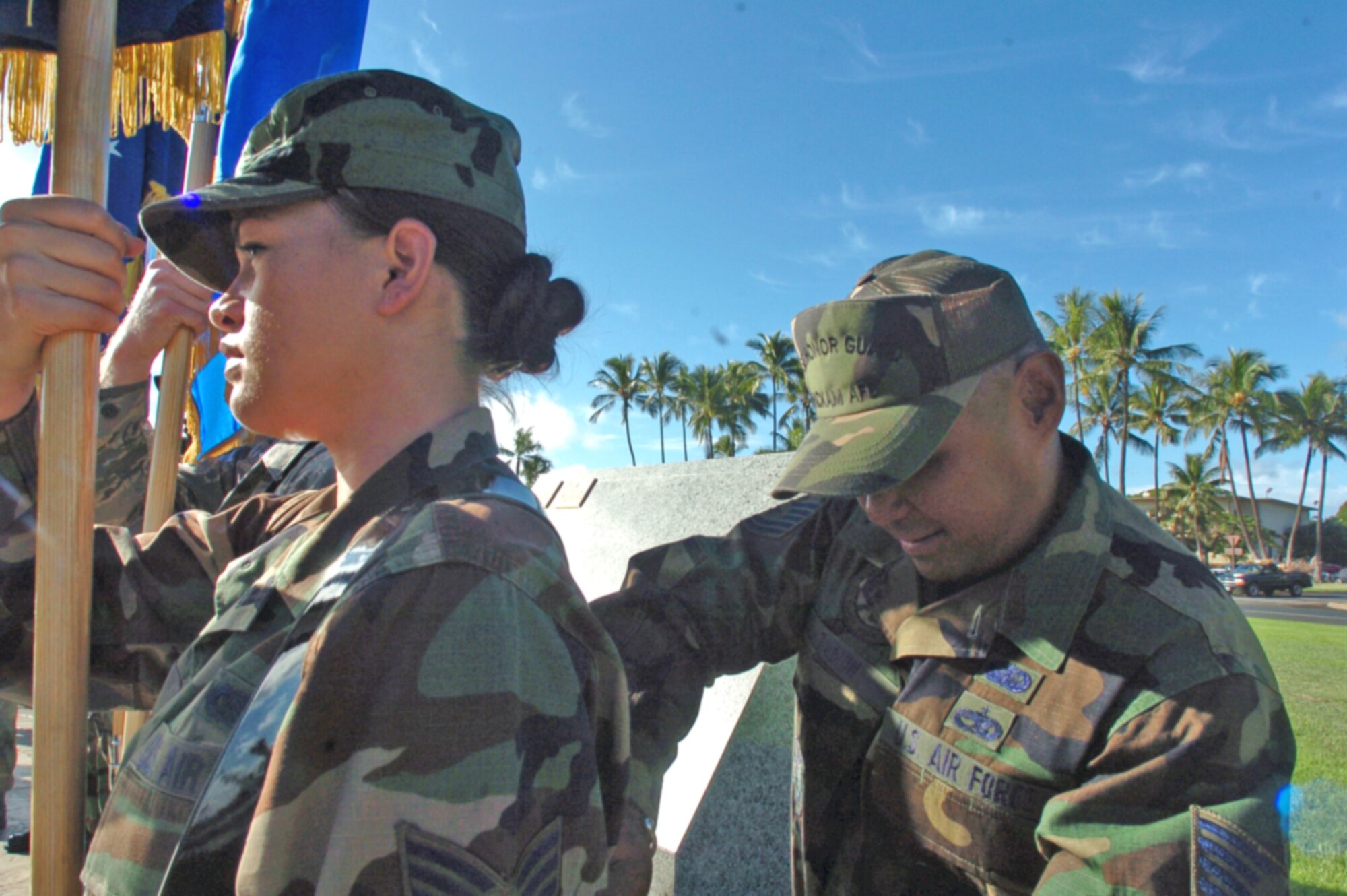 Senior Airman Melissa Keith from Yokota AB Honor Guard  receives harness help from Hickam AFB Honor Guard lead trainer Tech. Sgt. Sid Tabion Tuesday. Both Airmen are part of an all-Pacific Air Forces honor guard team preparing for the PACAF change of command scheduled for Friday 4 p.m. at Hickam’s Atterbury Circle Park. (U.S. Air Force photo/Mark Munsey)

