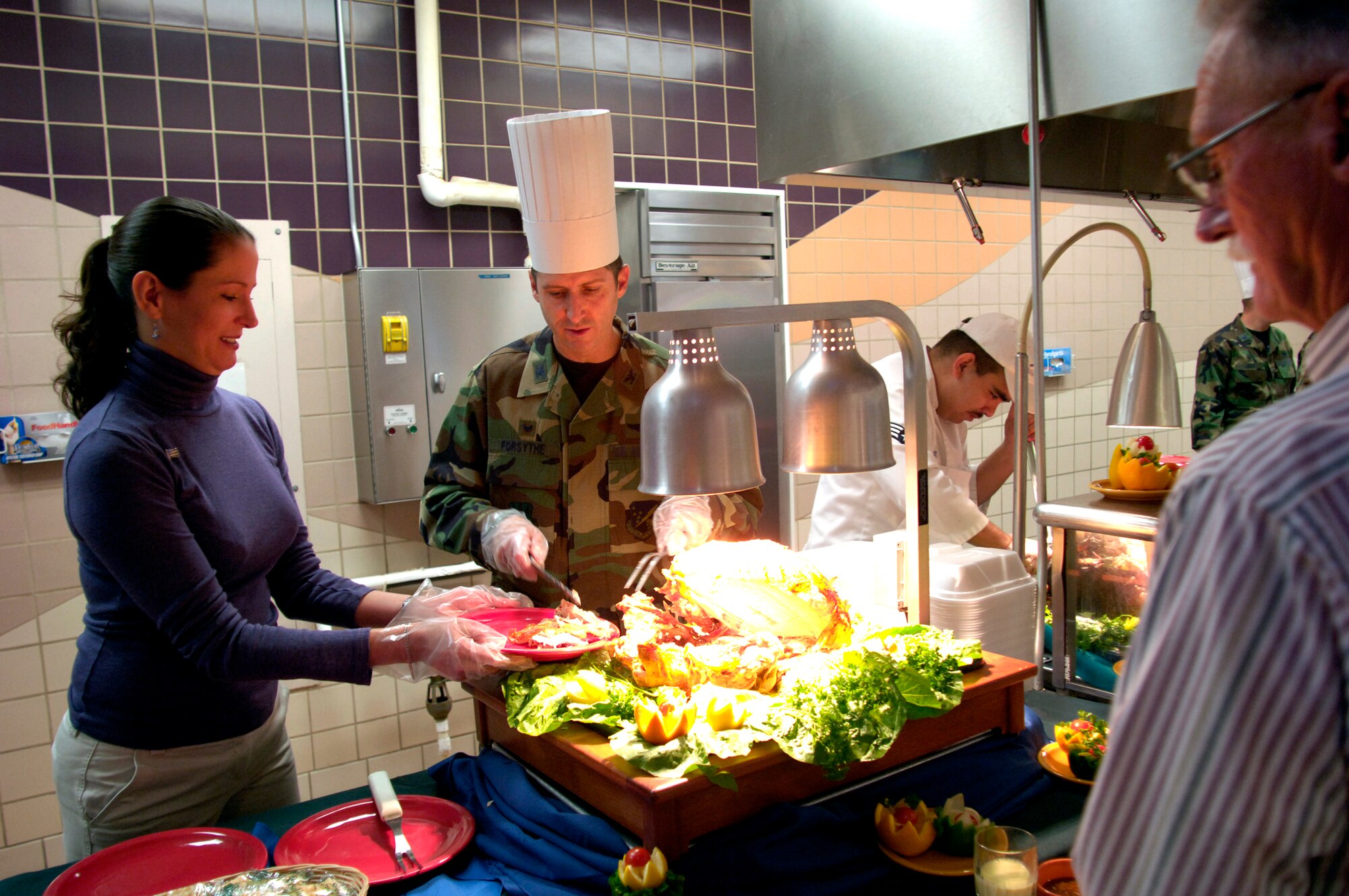 Col. Jack Forsythe, 49th Operations Group commander; and his wife Amy serve turkey during the Thanksgiving day dinner at Holloman AFB. This annual feast is put on by the 49th Services Squadron for the Holloman populace. (U.S. Air Force photo/ Staff Sgt. Jason Colbert)