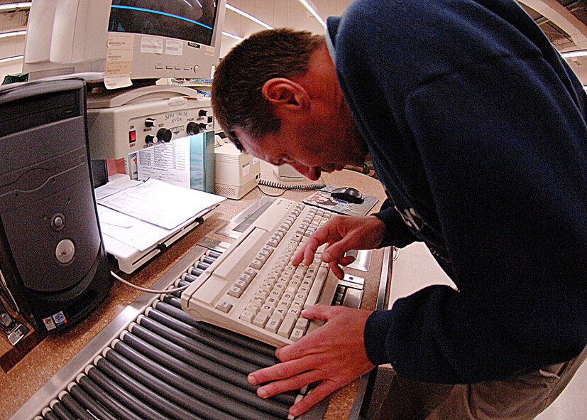 David Riley, an employee at Dyess' base supply store, uses computer technology to enhance and magnify text as he checks out customers Nov. 26. Mr. Riley is legally blind, but using this system he's able to be gainfully employed. (U.S. Air Force photo by Amn Stephen Reyes)