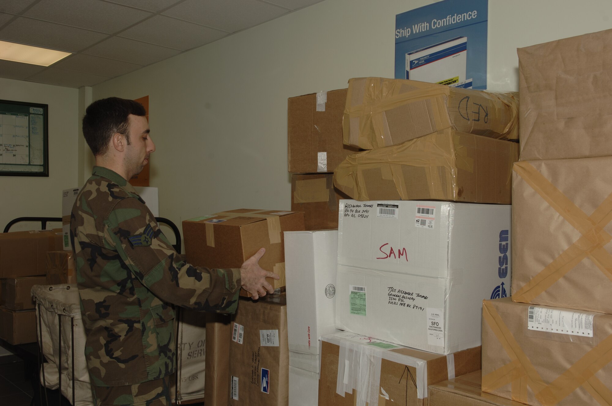 Senior Airman Carlos Dominquez, 39th Communications Squadron Official Document Center directory clerk, puts packages that are ready to be shipped in piles. There are many things to keep in mind when mailing packages such as ensuring the boxes are wrapped securely, taped well and have the correct information on the outside of the box. (U.S. Air Force photo by Senior Airman Tiffany Colburn).