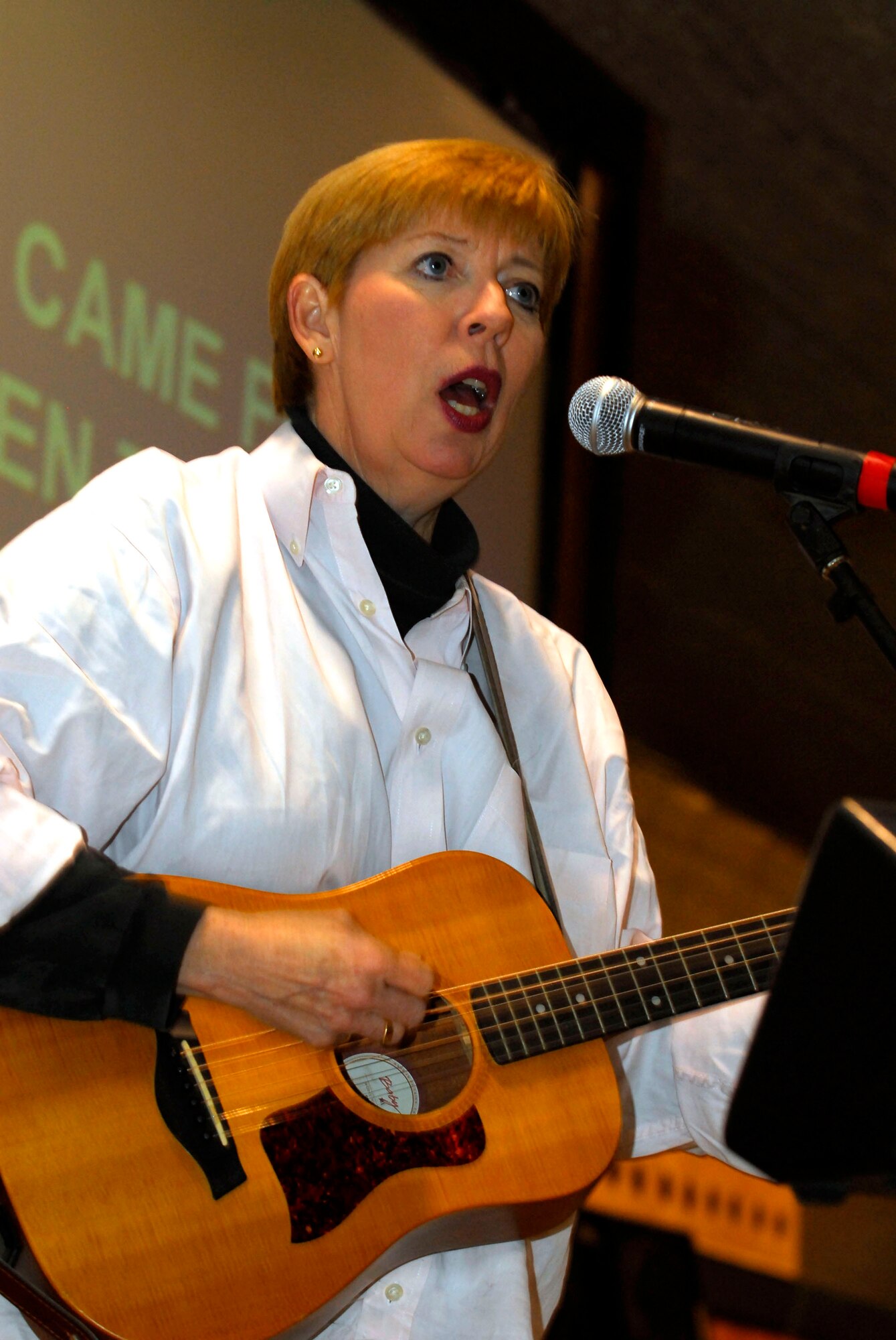 Betsy Brown of Heartsong Ministries performs inspirational songs for servicemembers Nov. 26 at Balad Air Base, Iraq. She encouraged those in attendance to dance and sing along with her. Ms. Brown is touring locations in the area of responsibility alongside motivational speaker and disabled veteran Vietnam War Dave Roever. (U.S. Air Force photo/Staff Sgt. Joshua Garcia) 
