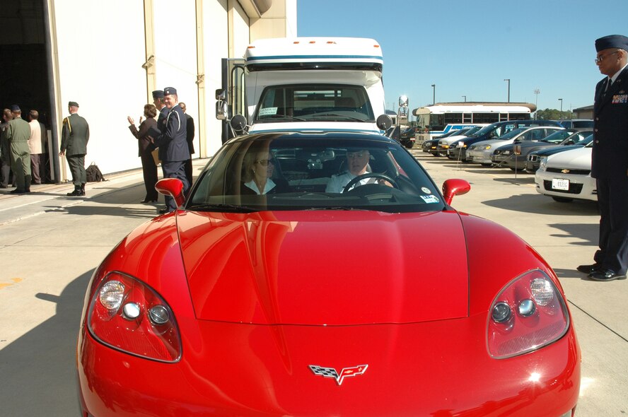 Lt. Gen. Mike Wooley, former Air Force Special Operations Command commander, drives away from Freedom Hangar in his red Corvette with his wife, Kathy, following the AFSOC change of command ceremony 27 Nov. at Hurlburt Field, Fla. General Wooley relinquished command to Lt. Gen. Donny Wurster and will retire Jan. 1 after more than 35 years of Air Force active-duty service. (U.S. Air Force photo/Senior Master Sgt. Tom Wood)