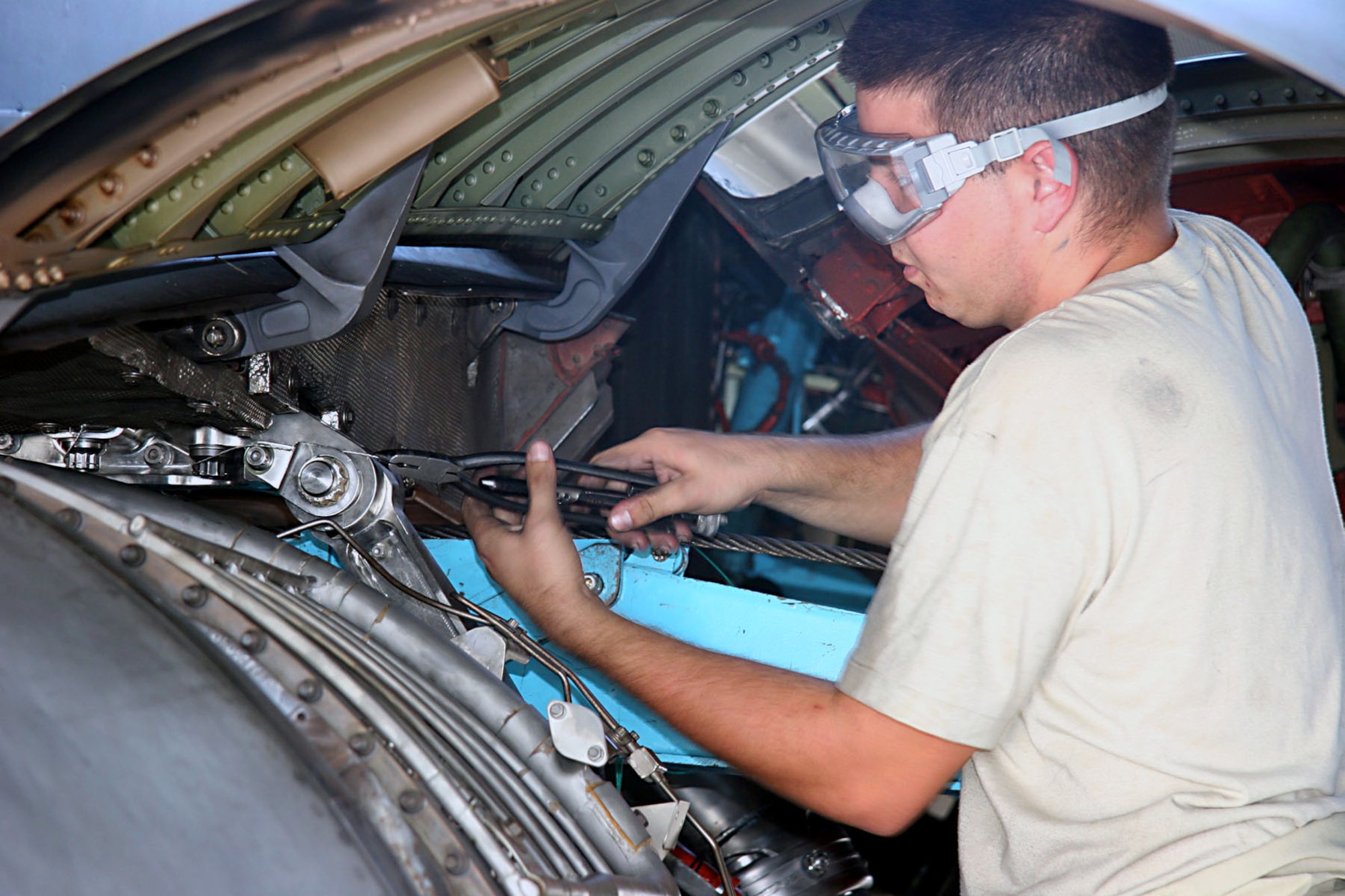 Airman 1st Class Louis Martens finishes installing safety wires on the engine mounts of a replacement engine on a KC-10 Extender Nov. 23.  Airman Martens is with the 380th Expeditionary Aircraft Maintenance Squadron at an air base in Southwest Asia.  (U.S. Air Force photo/Master Sgt. Ruby Zarzyczny)
