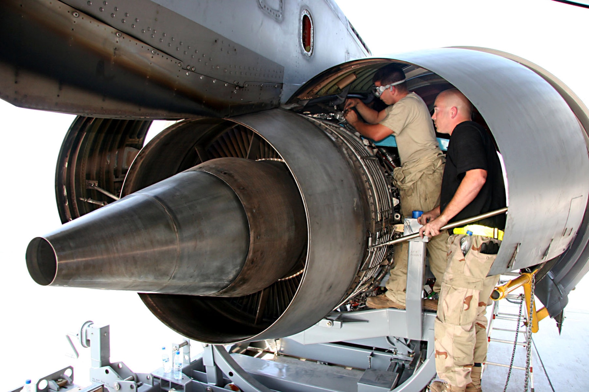 Staff Sgt. Joseph Dodson stands by to assist as Airman 1st Class Louis Martens finishes installing safety wires on the engine mounts of a replacement engine on a KC-10 Extender Nov. 23.  Sergeant Dodson and Airman Martens are with the 380th Expeditionary Aircraft Maintenance Squadron at an air base in Southwest Asia.  (U.S. Air Force photo/Master Sgt. Ruby Zarzyczny)