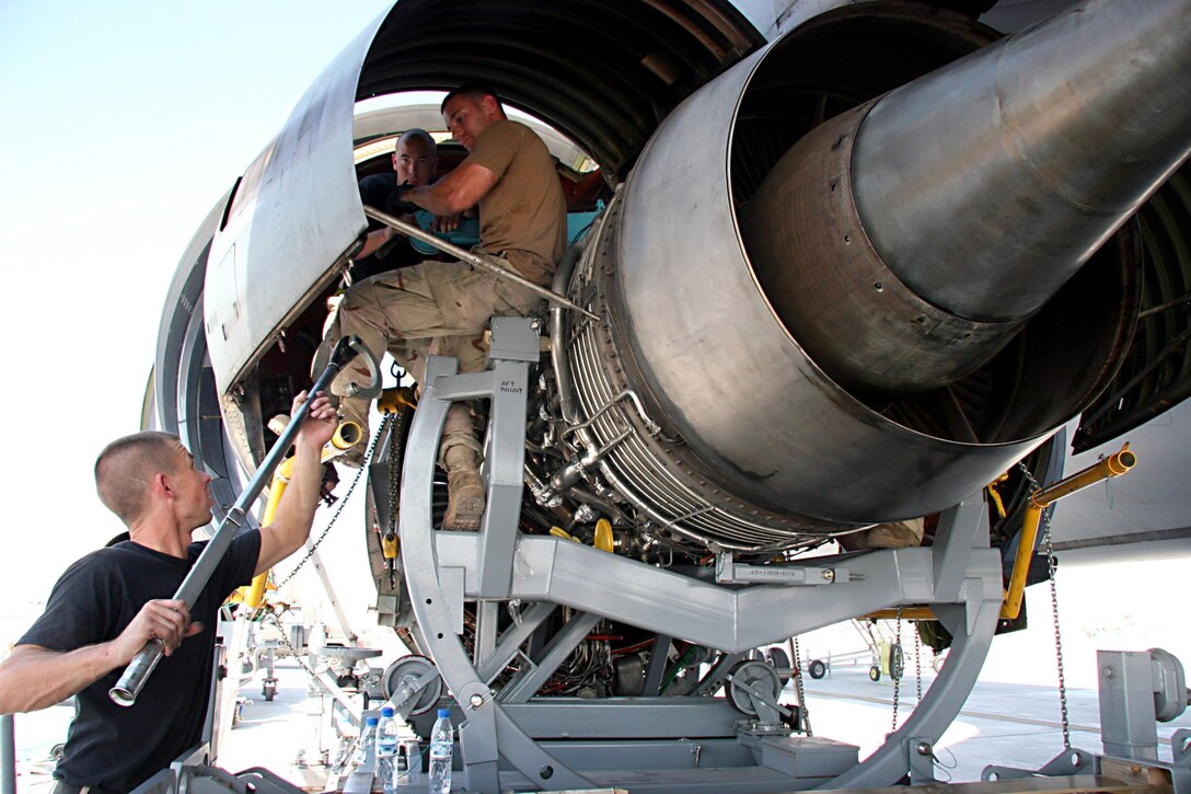 Staff Sgt. Kevin Brown hands Staff Sgt. Jamie Sherwood a torque wrench as Staff Sgt. Joseph Dodson stands by to complete the installation of a replacement engine on a KC-10 Extender Nov. 23.  It took a maintenance team two days to remove the old engine and install the new engine.  The sergeants are with the 380th Expeditionary Aircraft Maintenance Squadron at an air base in Southwest Asia.  (U.S. Air Force photo/Master Sgt. Ruby Zarzyczny)