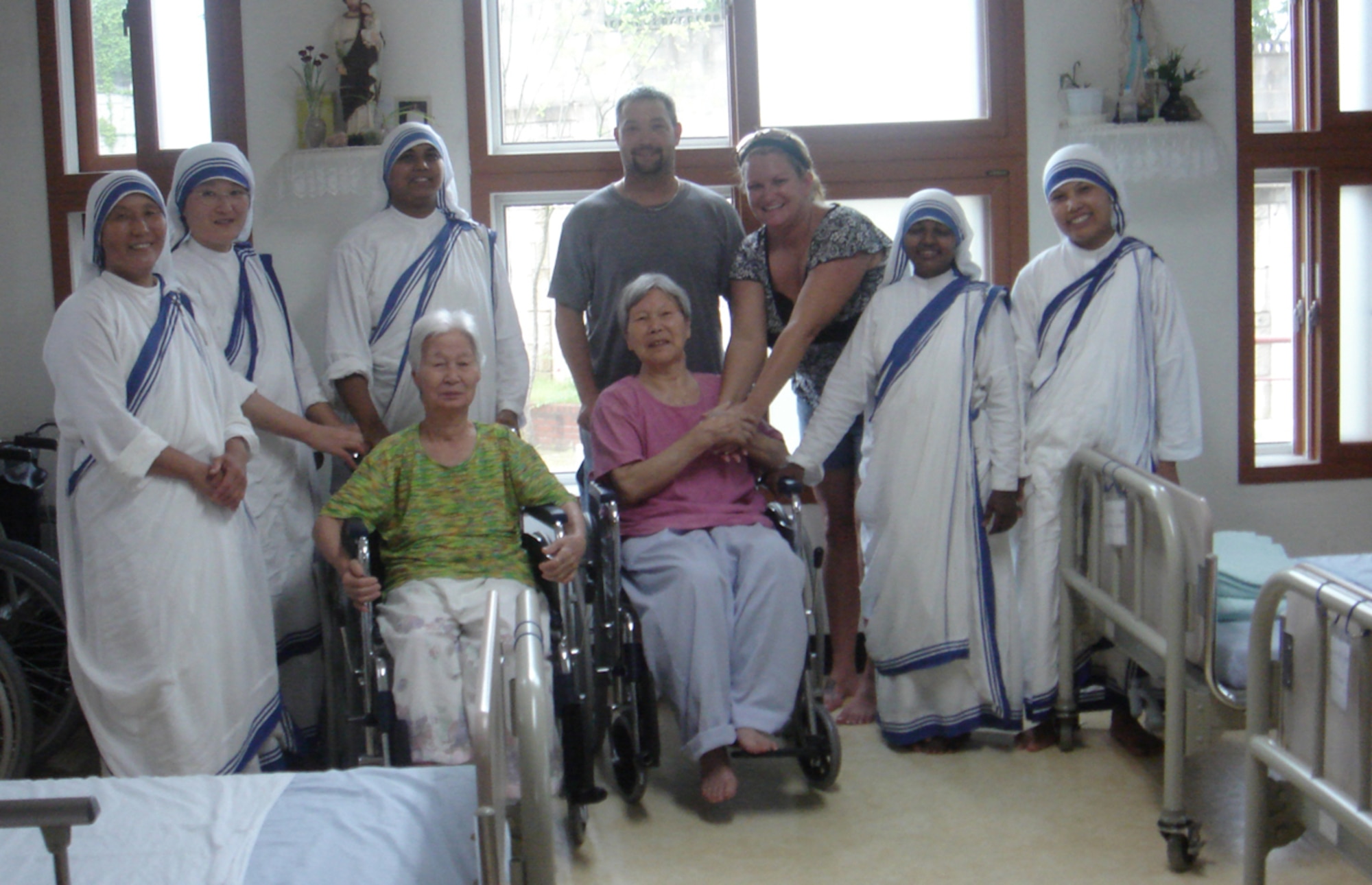SIN-CHON-DONG, Republic of Korea --  During his mid-tour leave, Tech. Sgt. Shannon Davis visited the Home of the Sacred Heart with his wife Danelle. Here they pose for a picture with the sisters of the Missionaries of Charity and some of the women who stay at the mission. (Courtesy photo)