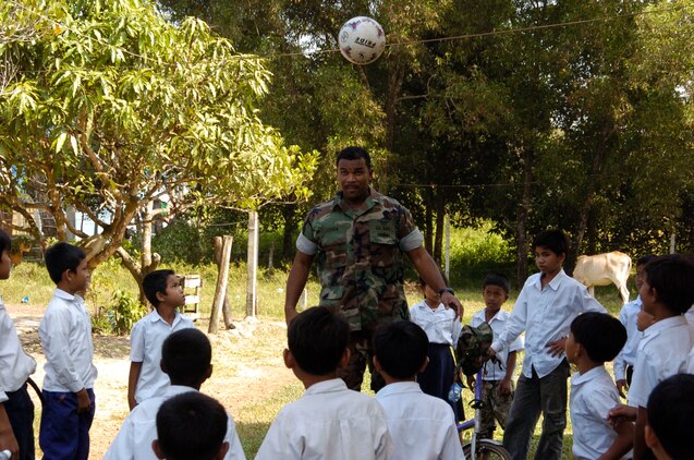 Sihanoukville, Kingdom of Cambodia (Nov. 29, 2007) - Culinary Specialist 1st Class (SW/AW) Rosco Cohen, and assigned to Amphibious Squadron Eleven, plays soccer with the students from the Chamka Kaosu school during a community relations project, Nov. 29.  Essex and the embarked 31st MEU arrived in Sihanoukville, Kingdom of Cambodia, Nov. 26, for a scheduled port visit that gives Sailors and Marines the opportunity to participate in friendship-building community relations events, medical and dental projects and professional exchanges.  These friendship-building events are being conducted with the cooperation of the Cambodian military and the Kingdom of Cambodia.  The visit also provides Sailors and Marines the opportunity to meet local citizens and experience the customs and traditions of the Cambodian people.  Essex is the lead ship of the only forward-deployed U.S. Expeditionary Strike Group and serves as the flagship for CTF 76, the Navyâ??s only forward-deployed amphibious force commander.  Task Force 76 is headquartered at White Beach Naval Facility, Okinawa, Japan, with a detachment in Sasebo, Japan.  U.S. Navy photo by Mass Communication Specialist 1st Class (AW) Jeffrey Ballge