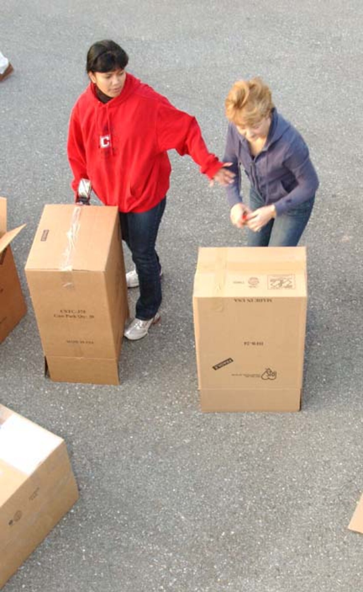 ANDREWS AIR FORCE BASE, Md. -- Lt. Col. Katherine Pallozzi, Chief of Protocol for the Chief of the Air Force Reserve, helps Jan Bradley, spouse of Air Force Reserve Command commander and chief of the Air Force Reserve Lt. Gen. John A. Bradley, seal boxes to fill with goods destined for villages in Afghanistan and Kyrgyzstan Nov. 19. (U.S. Air Force photo/Staff Sgt. Amaani Lyle)