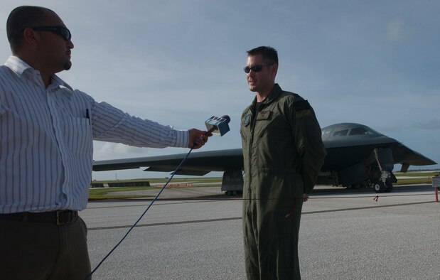 Reporter Mr. Clynt Ridgell interviews Capt. Justin Grieves, 393rd Expeditionary Bomb Squadron weapons and tactics officer on Andersen’s airfield during a military community event Nov. 21. This allowed the local military community, including family members, to learn more about the unique aircraft that make up the Andersen flying mission and provide deterrence against aggressors for the Western Pacific region. (U.S. Air Force photo/Senior Airman Brian Kimball)