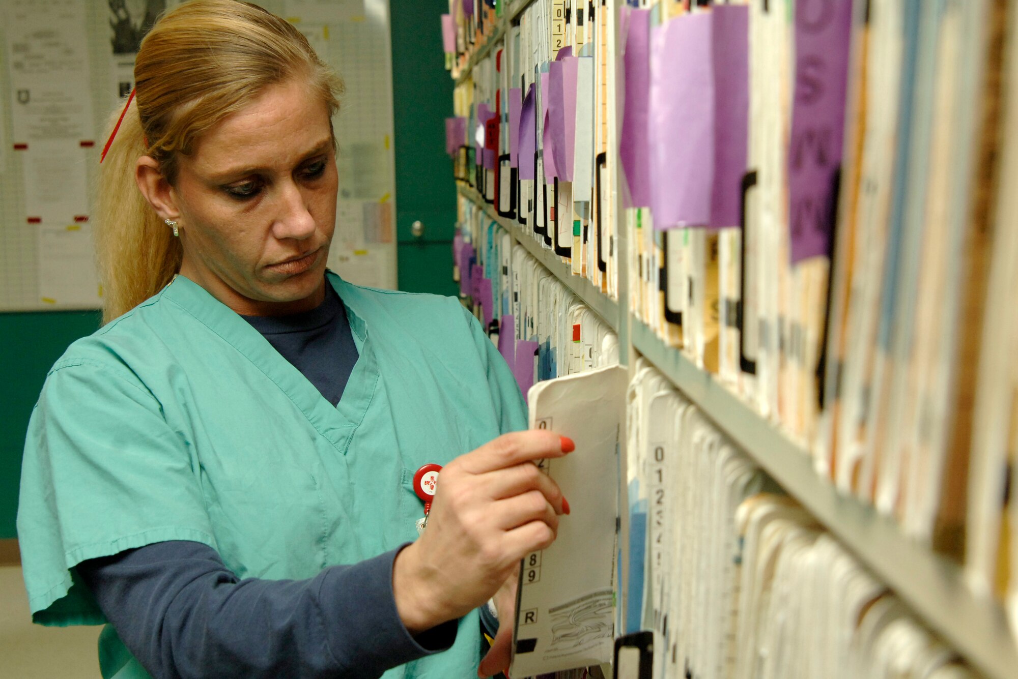 MCCONNELL AIR FORCE BASE, Kan. -- Amy Clark, 22nd Aero Medical Dental Squadron, searches for a patient record at the dental clinic Nov. 21. The dental clinic has a mixture of active duty and civilians working there. (Photo illustration by Airman 1st Class Roy Lynch III) 