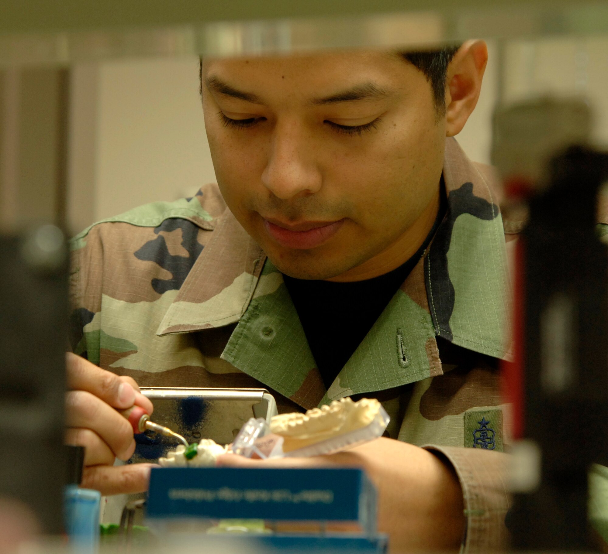 MCCONNELL AIR FORCE BASE, Kan. -- Staff Sergeant Richard Lopez, 22nd Aero Medical Dental Squadron, is waxing a crown at the dental clinic Nov. 21.  The dental clinic has a mixture of active duty and civilians working there. Due to manning, the dental clinic can only accept active duty personnel.  (Photo by Airman 1st Class Roy Lynch III) 