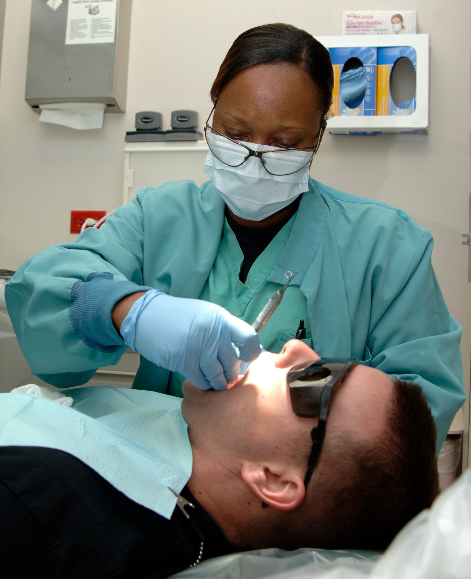 MCCONNELL AIR FORCE BASE, Kan. -- Staff Sergeant Aretha Sterling, 22nd Aero Medical Dental Squadron, works on Staff Sergeant Travis Winngham, 22nd Civil Engineer Squadron, at the dental clinic Nov. 21. The goal of the dental clinic is to have 60 percent Class 1 World Wide Deployable on base. (Photo by Airman 1st Class Roy Lynch III) 