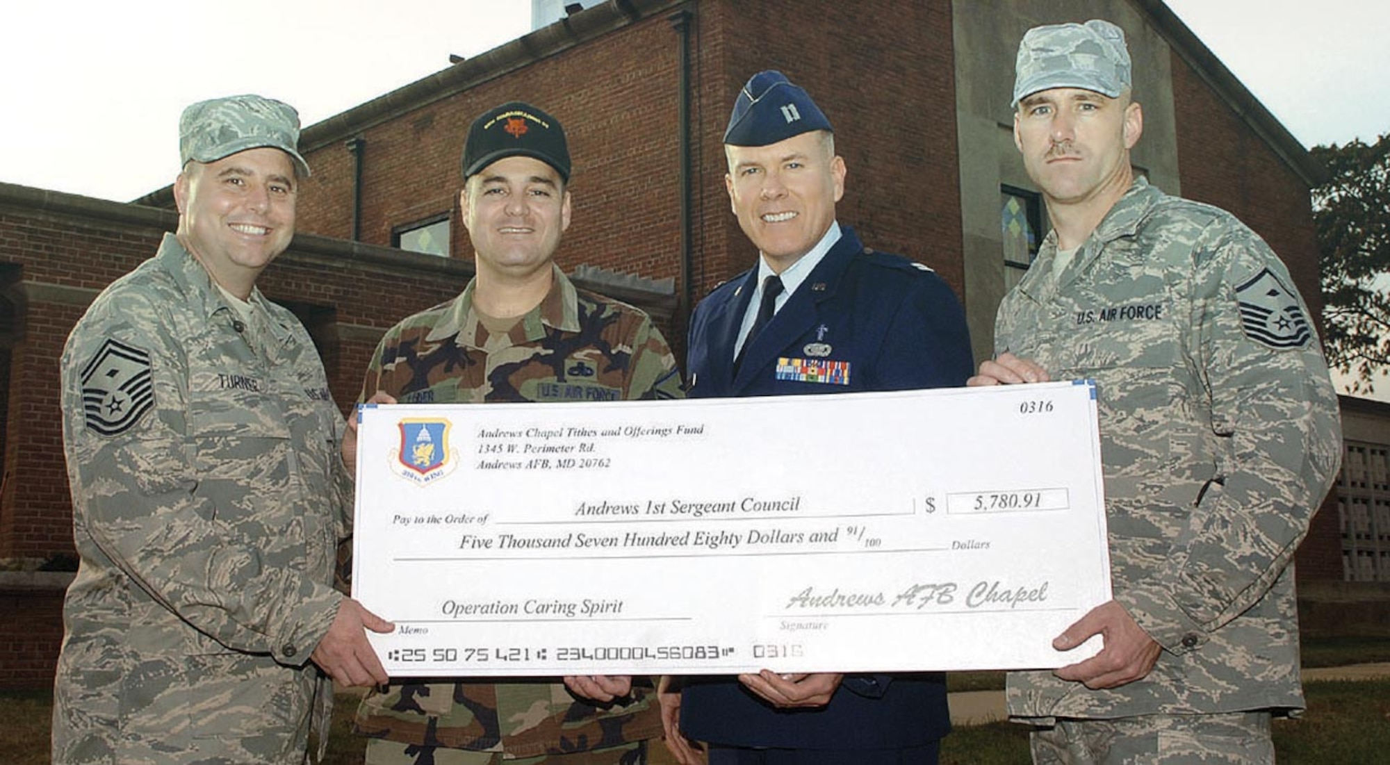Ch. (Capt.) Andrew Thornley, 316th Wing Protestant Chaplain, presents the oversized check to (from left) Senior Master Sgt. John Turner, 316th Civil Engineer Squadron first sergeant, Master Sgt. Craig Coder, 89th Communications Squadron first sergeant, and Master Sgt. Mario Cefalo, 79th Aerospace Medicine Squadron, Surgical Operations Squadron and Dental Squadron first sergeant, for $5,780.91 as a part of Operation Caring Spirit to help Airmen in need during the holiday season.
(US Air Force/SrA Jeff Andrejcik)