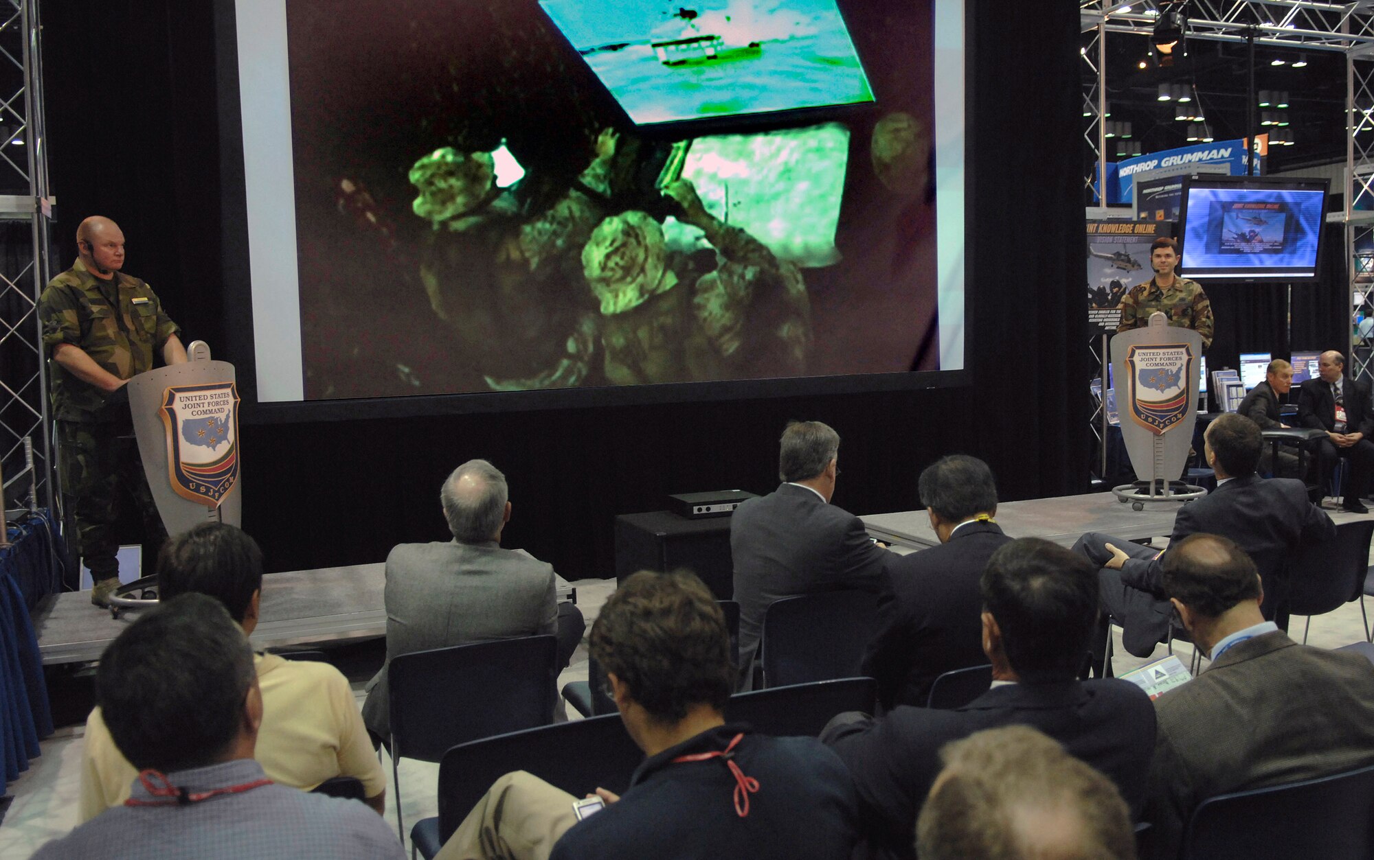 Swedish Lt. Col. Ulf Jinnestrend (left) and Maj. Emanuel Cohan brief industry leaders while watching a simulated hostage rescue mission Nov. 27 during the Interservice/Industry Training, Simulation and Education Conference in Orlando, Fla. Colonel Jinnestrend is the Swedish armed forces operations directorate director of staff, and Major Cohan is the U.S. Central Command communications planner at Joint Forces Commnad. (U.S. Air Force photo/Tech. Sgt. Larry A. Simmons)