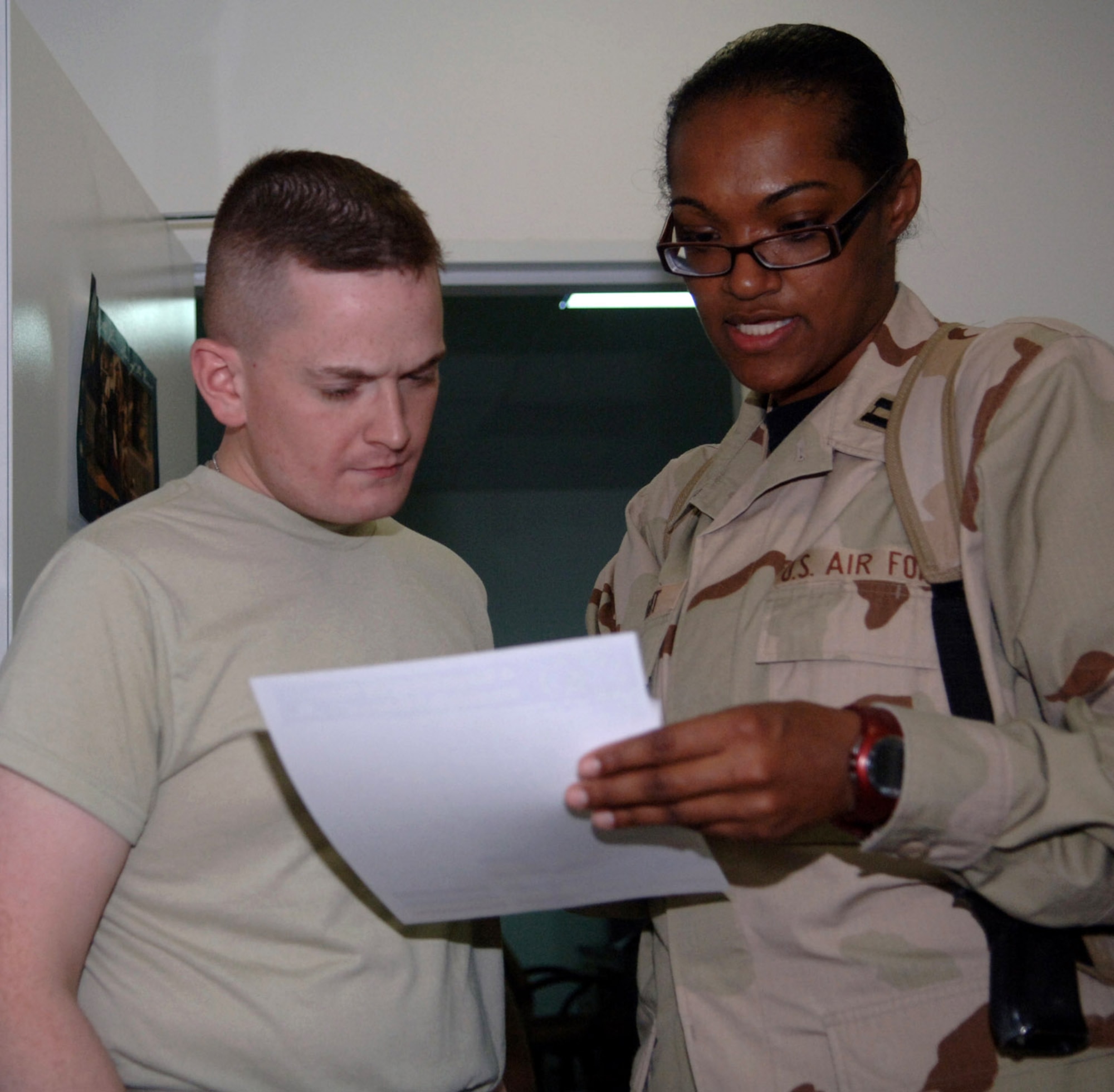 Capt. Saunya Bright, a 332nd Expeditionary Medical Support Squadron nutrition flight dietician, discusses with Airman 1st Class David Mann, a 332nd Air Expeditionary Wing chaplain?s assistant, the results of his body-composition assessment. The body-composition analysis measures body-mass index, total amount of body water and body fat percentage, and is a more accurate way to determine fitness level. Captain Bright is deployed from Lackland Air Force Base, Texas, and Airman Mann is deployed from Laughlin AFB, Texas. (U.S. Air Force photo/Senior Airman Terri Barriere)