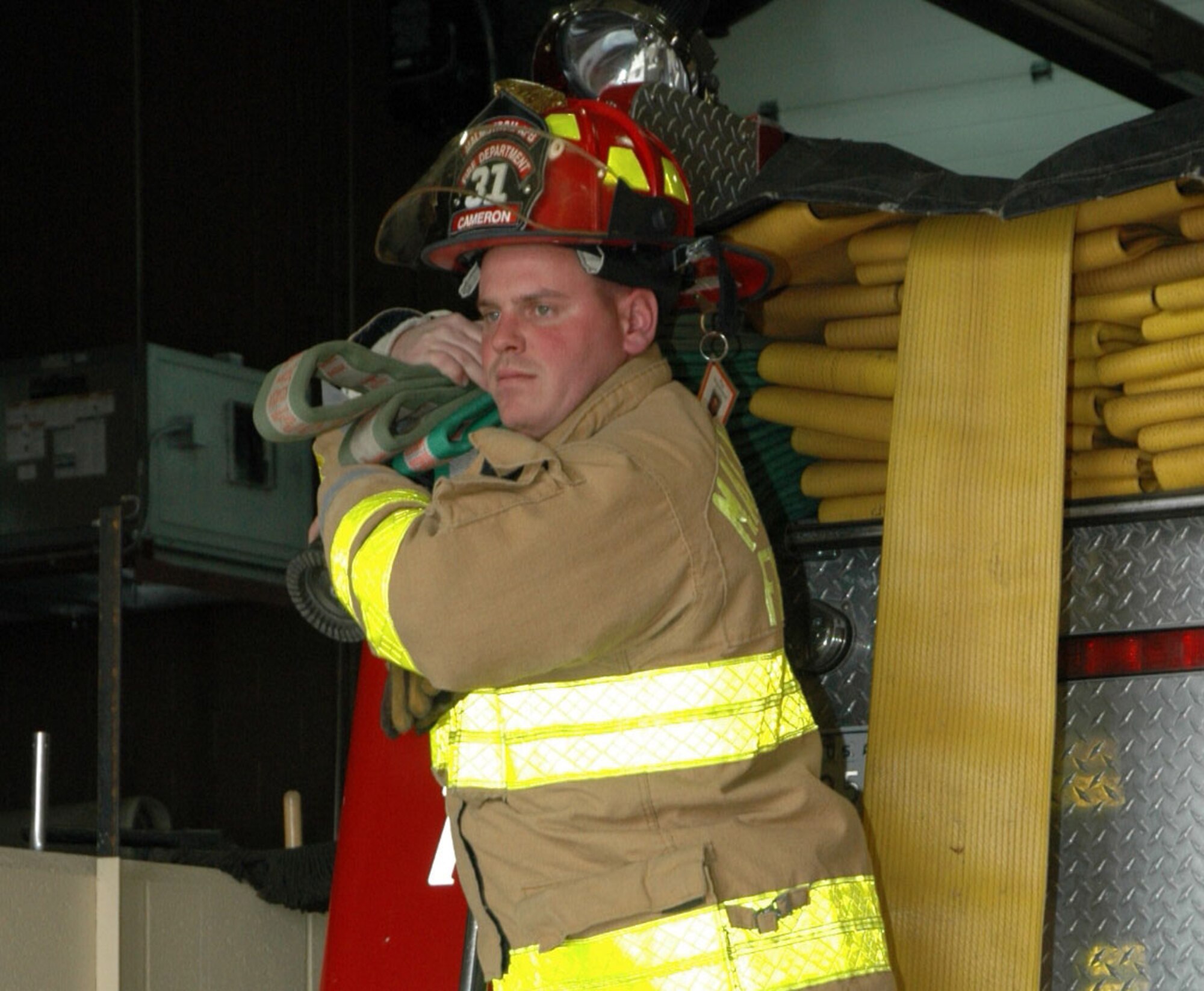 Staff Sgt. Dennis Cameron, 341st Civil Engineer Squadron firefighter, pulls a hose off a fire truck. Sergeant Cameron was awarded the Great Falls 2007 firefighter of the year award. (U.S. Air Force photo/Valerie Mullett)
