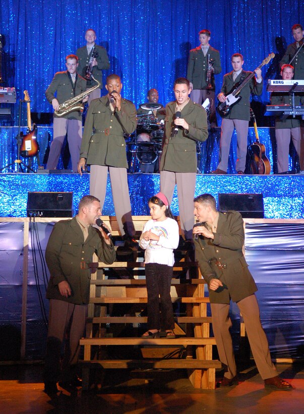 SOTO CANO AIR BASE, Honduras – Entertainers from the Air Force’s musical performance team Tops in Blue serenade a young Honduran girl at a show here Nov. 11.  The performance was the fourth time the travelling group has visited Joint Task Force-Bravo.  (U.S. Air Force photo by Staff Sgt. Austin M. May)