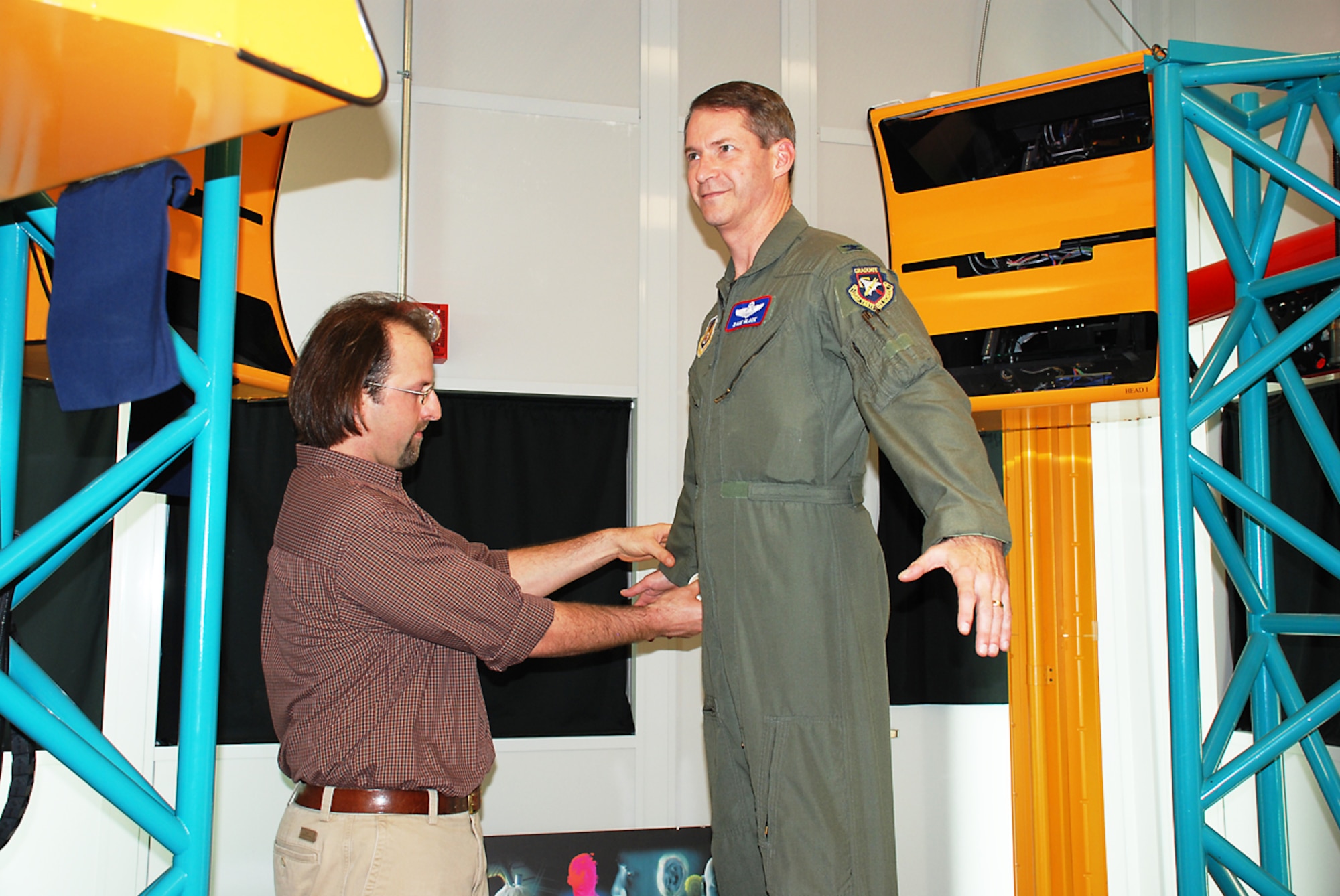 Scott Fleming (left), anthropologist with the Air Force Research Laboratory Human Effectiveness Directorate, positions AFRL Vice Commander Col. David B. Glade II in the lab's 3-dimensional whole-body surface scanner as he explains how the body measurement scanning process works. (Photo by Chris Gulliford AFRL/RH)