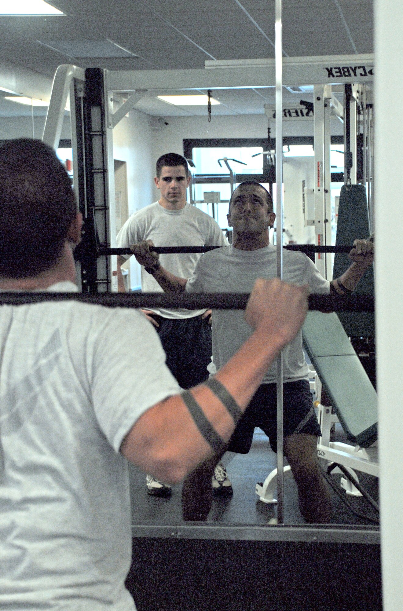 Senior Airman Patrick Briggs, 3rd Airlift Squadron loadmaster, performs squats at the Fitness Center as fellow 3rd AS loadmaster Senior Airman Brendan Proctor spots him. (U.S. Air Force photo/Tech. Sgt. Kevin Wallace)