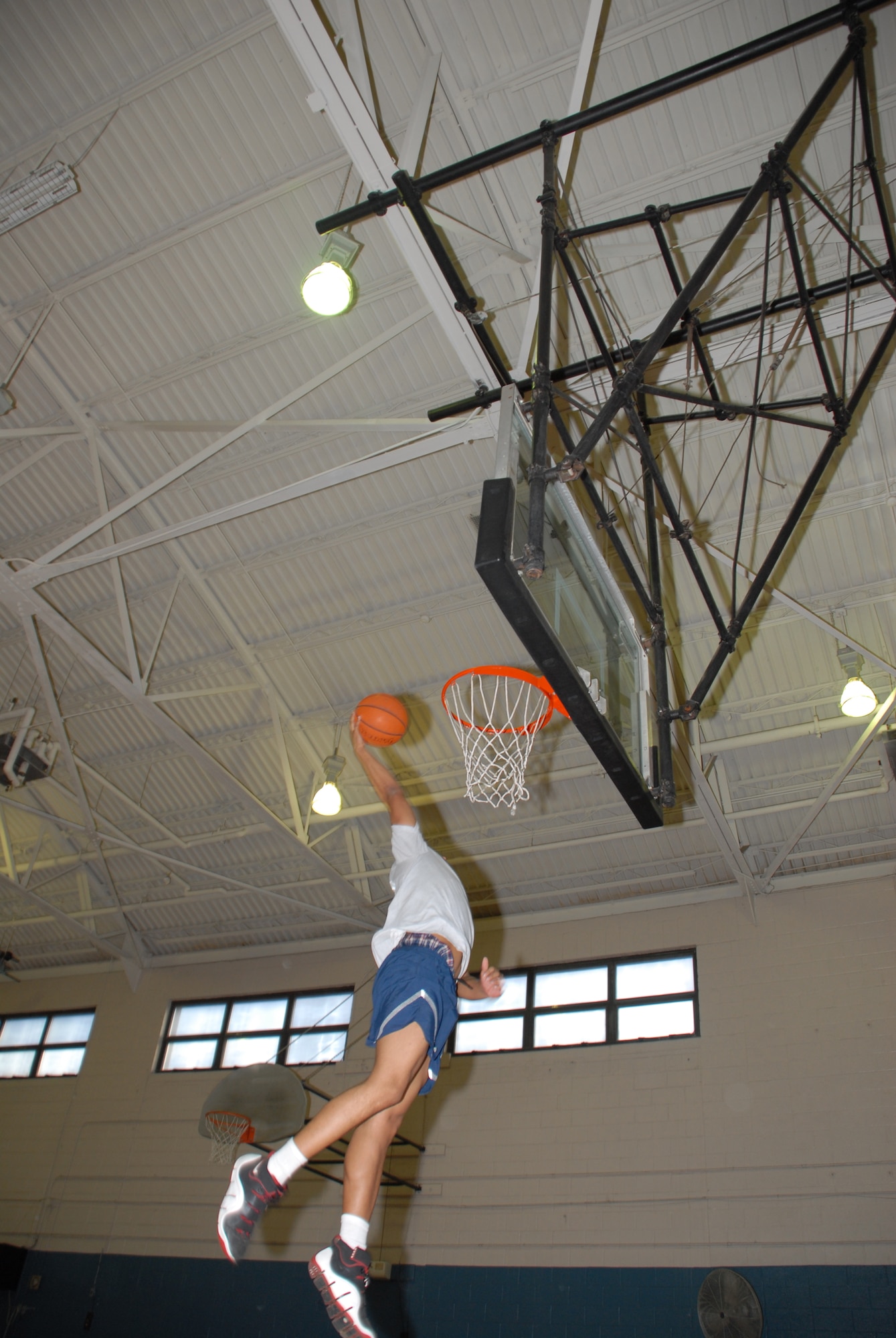 Airman 1st Class Kris Mack, 3rd Airlift Squadron loadmaster leaps for a slam dunk during a basketball game after his unit's physical training session. (U.S. Air Force photo/Tech. Sgt. Kevin Wallace)