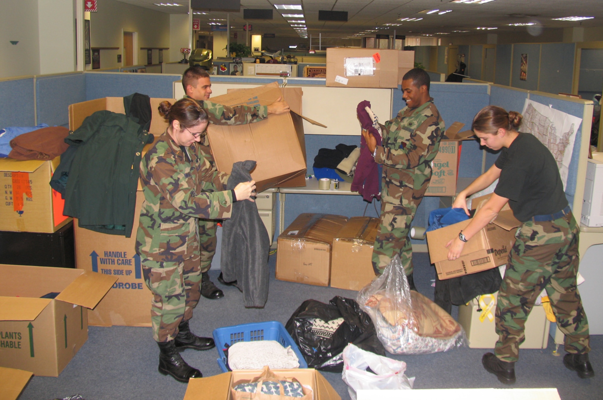 HANSCOM AFB, Mass. -- Hanscom lieutenants (from left) Holly Chernushin, 66th Comptroller Squadron, Josh Neustrom, 851st Electronic Systems Group, Karl Artis III, 66th Mission Support Squadron, and Felisa Dyrud, 66 MSS, sort and pack donated clothing items and blankets on Nov. 28. The clothes and blankets will be sent to Afghanistan and distributed to poor people living there. The lieutenants organized the clothing and blanket drive, which resulted in more than a dozen boxes of donated items, days before the Thanksgiving holiday as a means for Hanscom personnel to share their wealth with those less fortunate. (U.S. Air Force photo by 1st Lt. Lisa Spilinek)