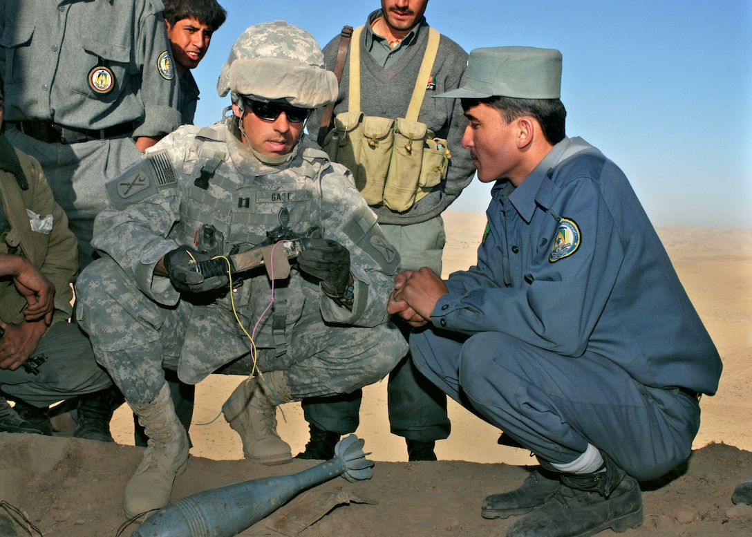 Army Capt. Stewart Gast looks at an improvised explosive device that was found and disabled by members of the Afghan National Police. Gast and others from his Police Mentoring Team learned about the device when they stopped at the observation post to check on Afghan National Police deployed during an operation against insurgents in northwest Faryab province. Photo by Petty Officer 1st Class David M. Votroubek, USN