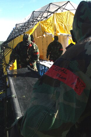 Lance Cpl. Phanark Sopal, and Cpl. Anthony Garcia, litter bearers, with the decontamination platoon, Chemical Biological Incident Response Force, II Marine Expeditionary Force, assist on the decontamination line here in November. Here, victims of a chemical, biological, radiological, nuclear, or high-yield explosive incident get cleaned of contaminants.