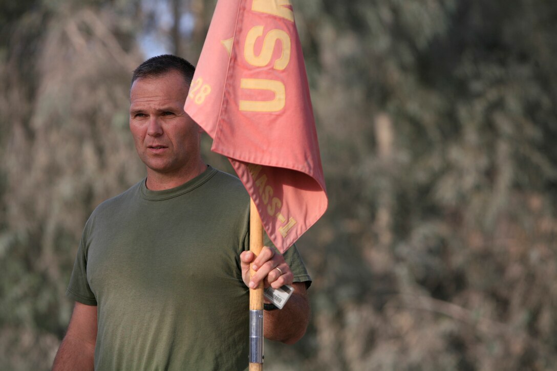 Sgt. Maj. John Halpin stands with the Marine Aviation Support Squadron 1 guidon before the Chieftains kick off the run in Fallujah, Iraq. Approximately 60 Marines in Fallujah, Iraq, joined their Chieftain counterparts at Cherry Point for the run. Helpin is the MASS-1 sergeant major.