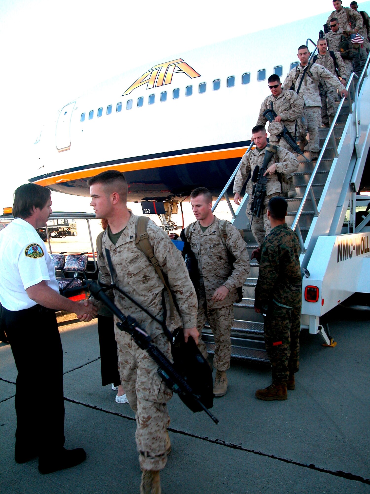 On Nov. 21, the day before Thanksgiving, a few hundred Marines flew into March ARB just barely making it home in time for turkey and cranberry sauce. The Marines are stationed at 29 Palms, Calif., and had been pulling a combat tour in the Middle East. Volunteer Laura Froehlich and John Martin (left) from the base fire department were joined by several siren-blaring fire trucks to greet the troops as they stepped off the aircraft and back onto American soil. (U.S. Air Force photo by Amy Abbott/452 AMW/PA)