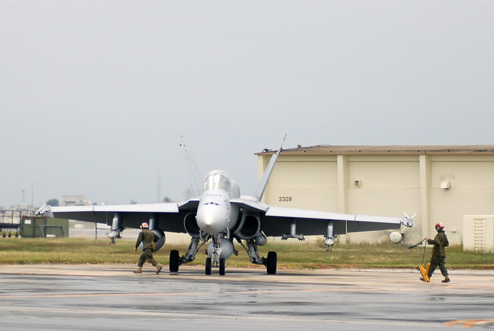 Marines rush to chalk an F/A-18 Hornet aircraft from Marine Aircraft Group 12 Nov. 28. Thrity-two F/A-18 Hornets from Marine Corps Air Station Iwakuni, Japan, started arriving here Nov. 28 to participate in Beverly High 08-02 and conduct other training. (U.S. Air Force photo/Airman First Class Kelly Timney) 