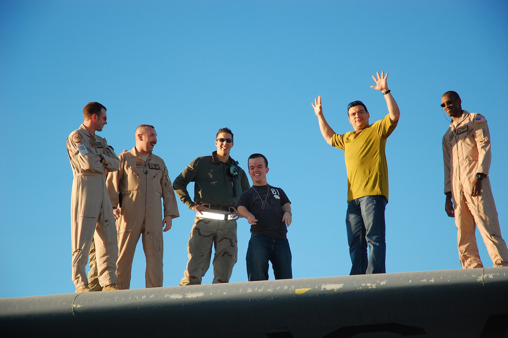 Comedian Carlos Mencia stands on the wing of a C-130 Hercules while visiting members of the 386th Air Expeditionary Wing Nov. 28 in Southwest Asia. Mr. Mencia and his crew traveled throughout the Middle East providing entertainment for deployed servicemembers. (U.S. Air Force photo/Staff Sgt. Tia Schroeder) 
