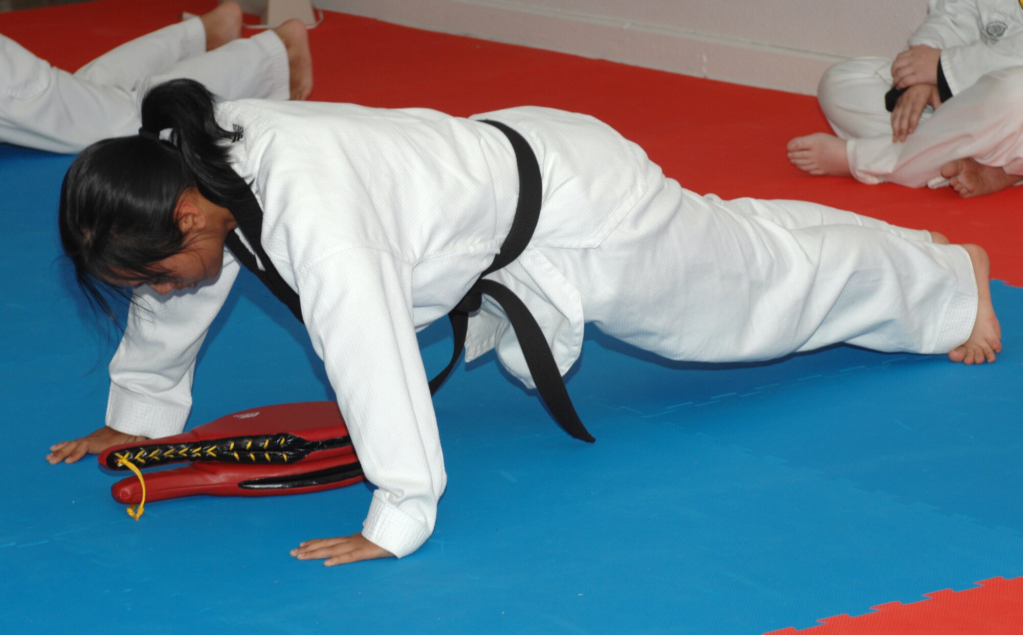 CANNON AIR FORCE BASE, N.M. -- A student from Force of One Martial Arts, owned by Master Sgt. Eric Suan, 27th Special Operations Support Squadron, sees how many push-ups she can do in Sergeant Suan's seventh annual kick-a-thon. Participants see how many push-ups, jumpropes and kicks they can do in one minute and proceeds from the kick-a-thon go to local community charities as well as to purchase new Taekwondo equipment. (U.S. Air Force photo by Airman 1st Class James Bell)