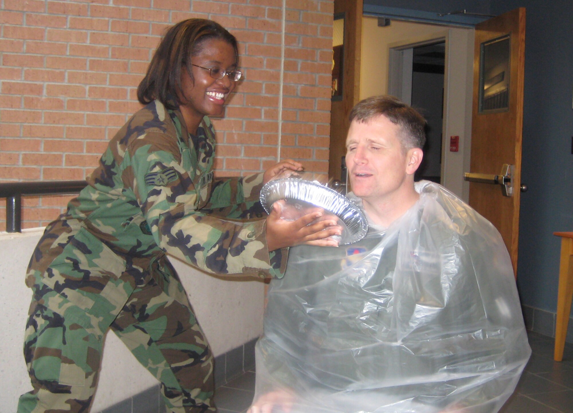 Senior Airman Hazel Butler, 14th Operations Support Squadron, serves a pie to Col. Jeff Dunn, 14th Flying Training Wing vice commander, Tuesday. Colonel Dunn was the lucky recipient of a pie due to the pie-in-the-face contest held by the Airman's Activity Council. Sonic Johnson, 14th FTW Public Affairs, and Diane Clardy, 14th FTW Protocol, also received pies Tuesday. (U.S. Air Force photo by Airman 1st Class Danielle Powell)