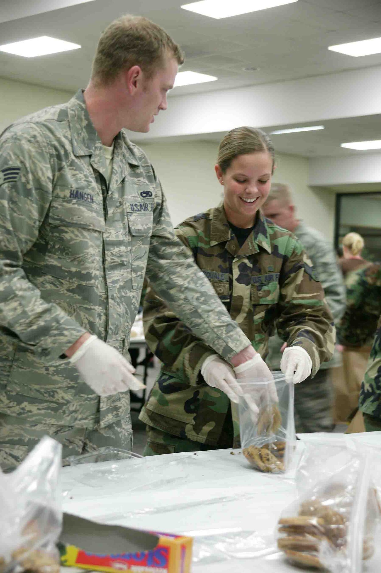 SHAW AIR FORCE BASE, S.C. --  Senior Airmen Matthew Hangen, 20th Equipment Maintenance Squadron, and Brooke Dipasquale, 20th Medical Operations Squadron, bag up cookies during the Shaw Cookie Drive Nov. 29 at the Community Activities Center. The Airman's cookie drive, sponsored by the Enlisted Spouses Club and the Officer and Civilian Spouses Club, received more than 60,000 cookies this year from local community and base volunteers. The cookies are distributed to Airmen across Shaw and to deployed Airmen and Soldiers as well. (U.S. Air Force photo/Staff Sgt. John Gordinier)
