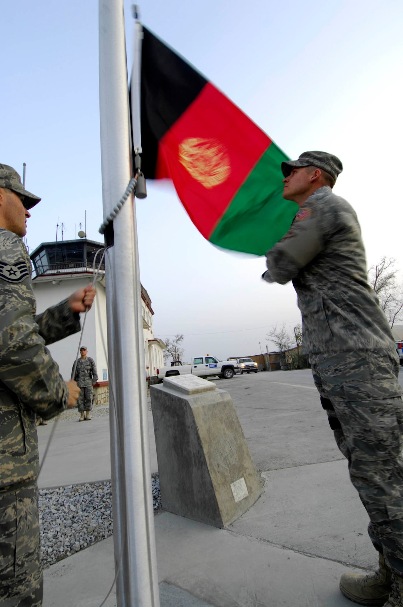 BAGRAM AIR BASE, Afghanistan - Staff Sgt. Jeremiah Hall (right) and Staff Sgt. Michael DeJesus, both members of the 455th Expeditionary Security Forces Squadron, raise the Afghan flag on a newly installed flagpole here, Nov. 30, 2007.
(U.S. Air Force photo/Staff Sgt. Joshua T Jasper)  (Released)