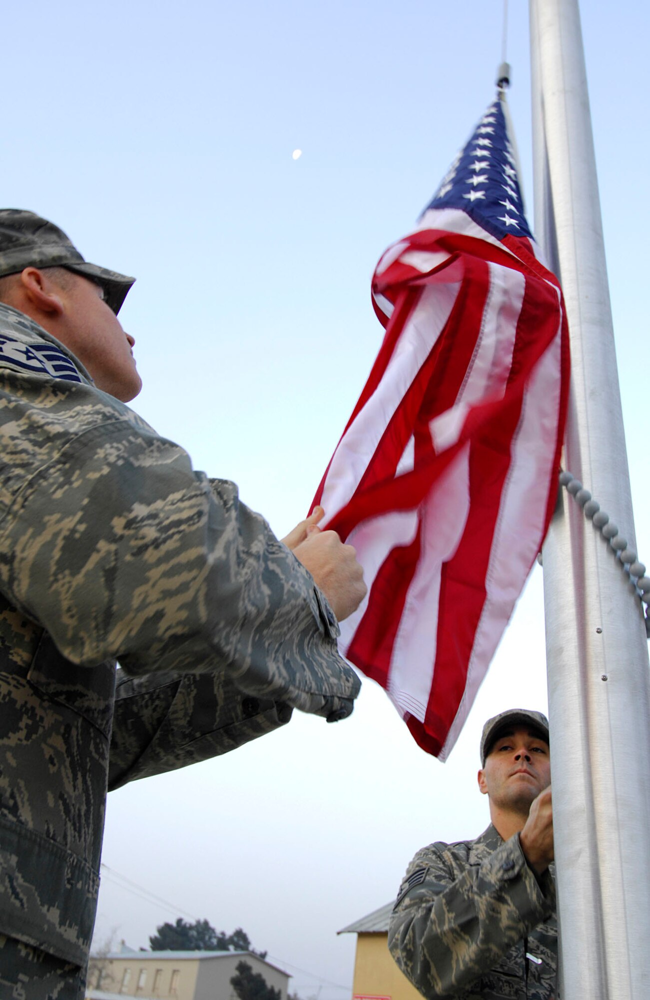 BAGRAM AIR BASE, Afghanistan - Staff Sgt. Jeremiah Hall (left) and Staff Sgt. Michael DeJesus, both members of the 455th Expeditionary Security Forces Squadron, raise the Afghan flag on a newly installed flagpole here, Nov. 30, 2007.
(U.S. Air Force photo/Staff Sgt. Joshua T Jasper)  (Released)
