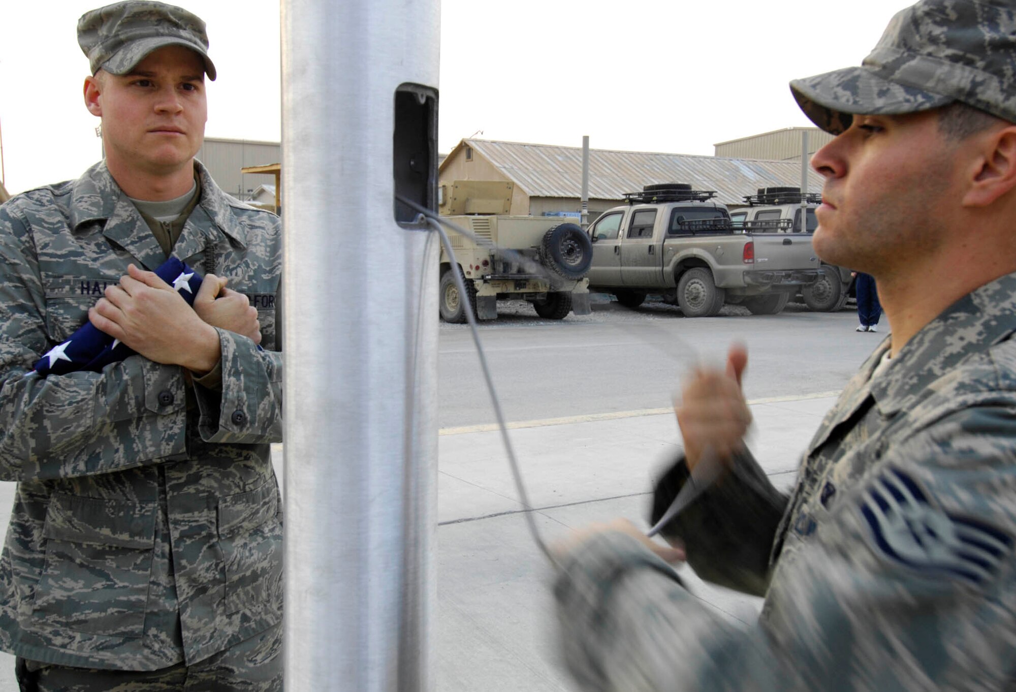 BAGRAM AIR BASE, Afghanistan - Staff Sgt. Jeremiah Hall (left) and Staff Sgt. Michael DeJesus, both members of the 455th Expeditionary Security Forces Squadron, raise the Afghan flag on a newly installed flagpole here, Nov. 30, 2007.
(U.S. Air Force photo/Staff Sgt. Joshua T Jasper)  (Released)