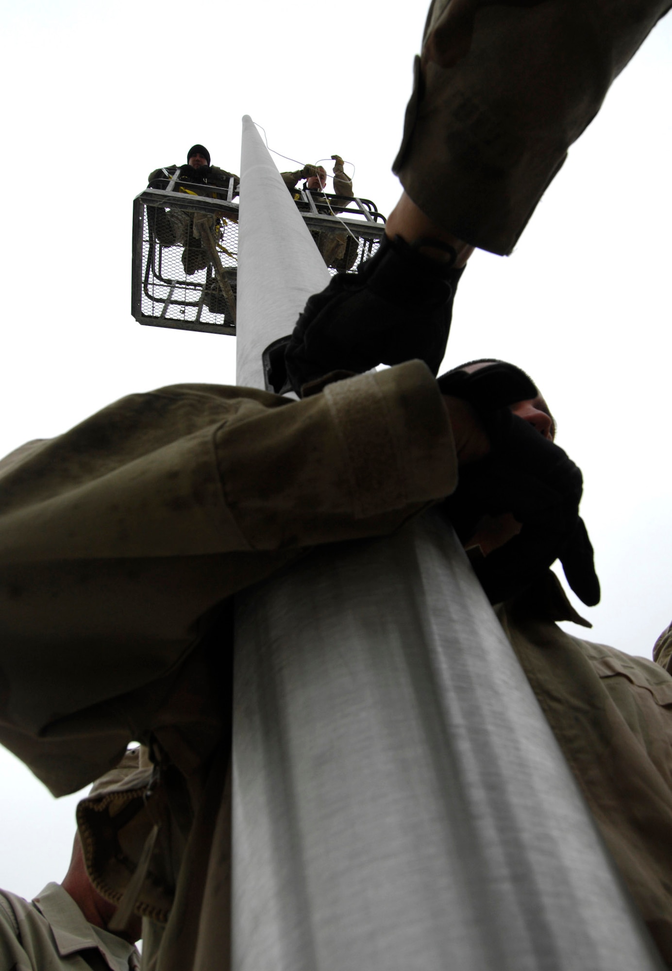 BAGRAM AIR BASE, Afghanistan - Members of the 455th Expeditionary Civil Engineering Squadron help install two new flagpoles on Camp Cunningham here, Nov. 29, 2007.  (U.S. Air Force photo/Staff Sgt. Joshua T Jasper)  (Released)