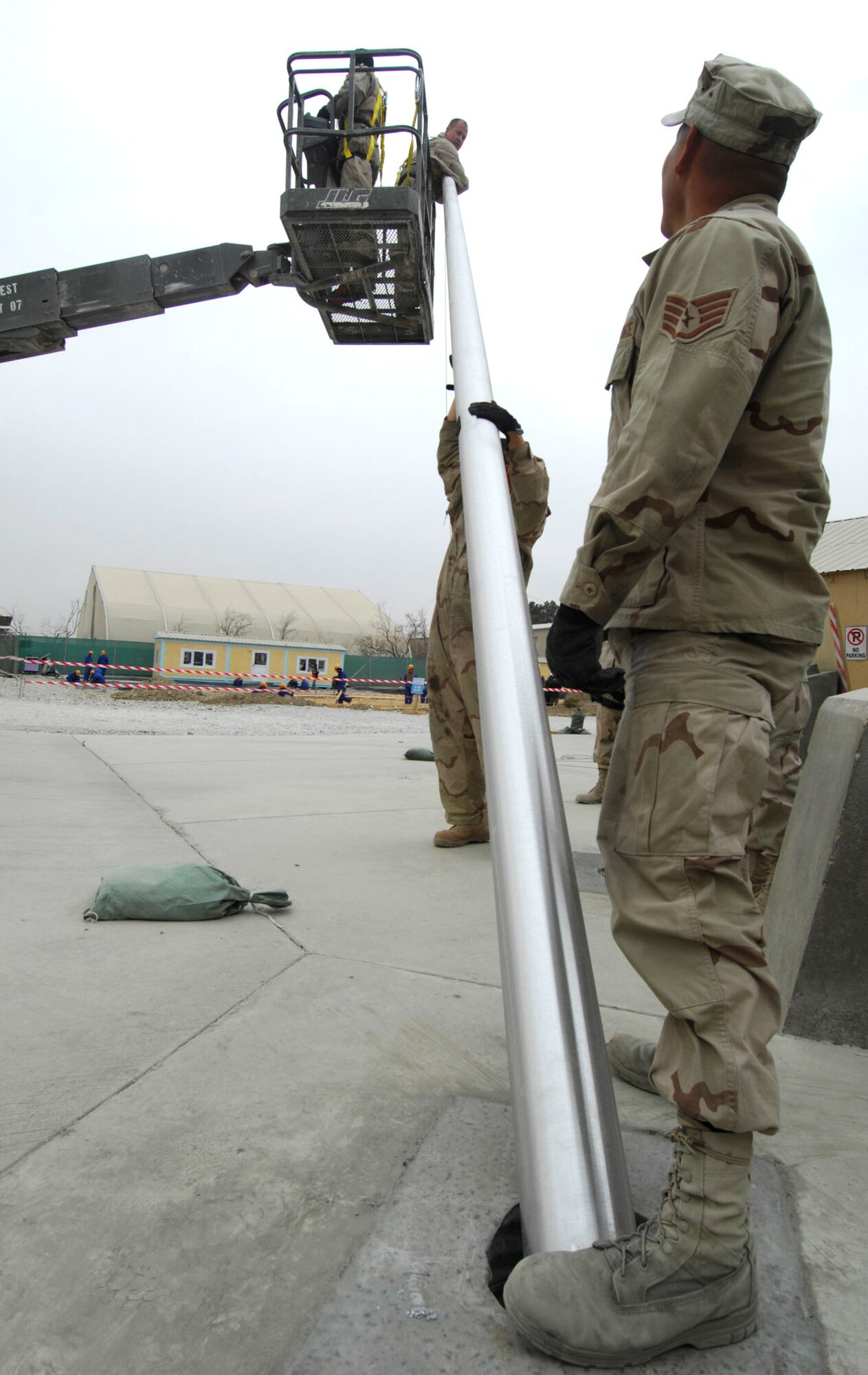 BAGRAM AIR BASE, Afghanistan - Members of the 455th Expeditionary Civil Engineering Squadron help install two new flagpoles on Camp Cunningham here, Nov. 29, 2007.  (U.S. Air Force photo/Staff Sgt. Joshua T Jasper)  (Released)