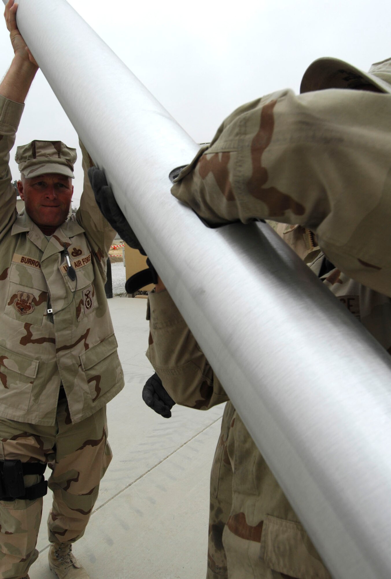 BAGRAM AIR BASE, Afghanistan - Chief Master Sergeant Stanley Burrows and members of the 455th Expeditionary Civil Engineering Squadron install two new flagpoles on Camp Cunningham here, Nov. 29, 2007. 
(U.S. Air Force photo/Staff Sgt. Joshua T Jasper)  (Released))