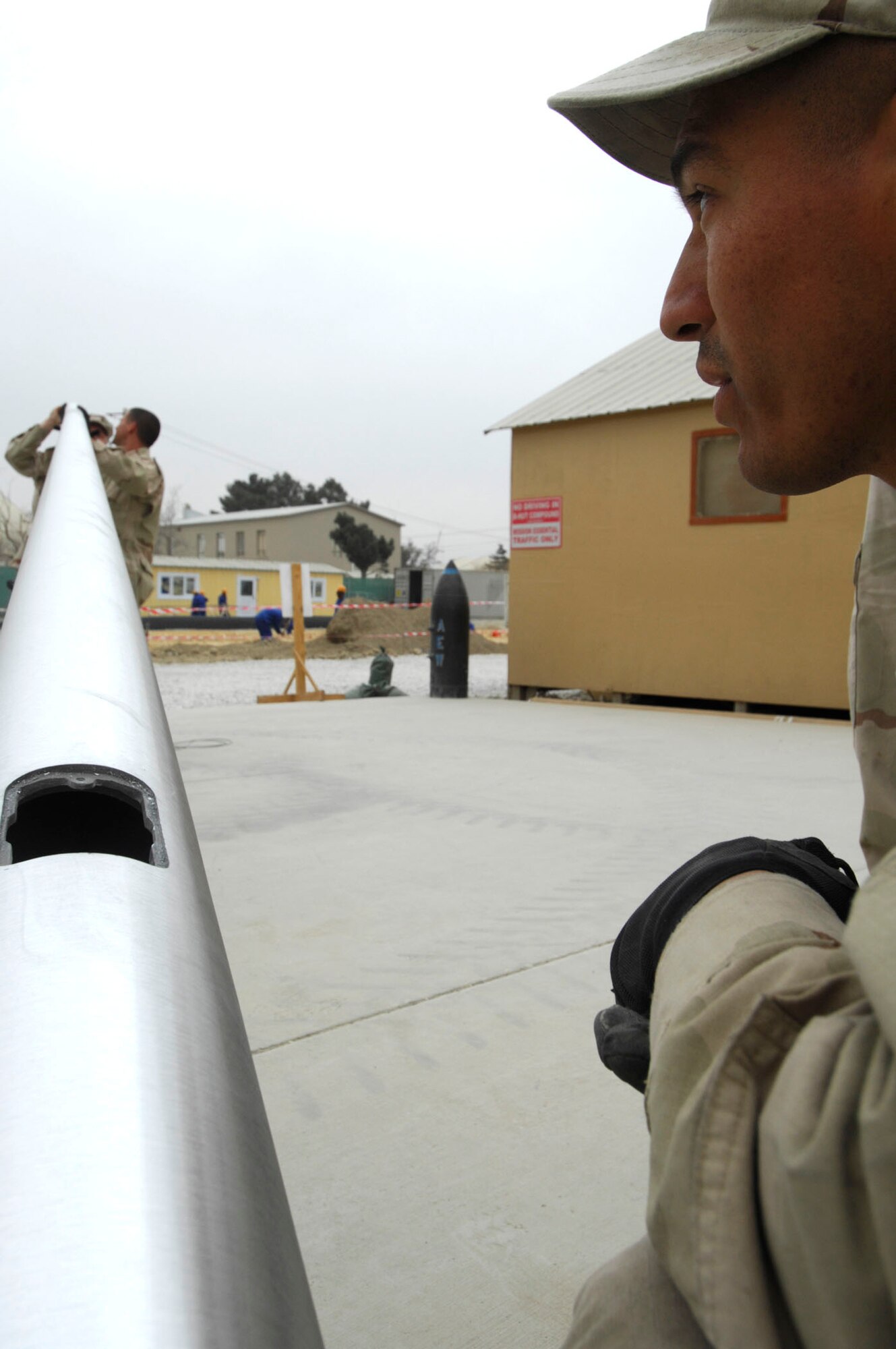 BAGRAM AIR BASE, Afghanistan - Members of the 455th Expeditionary Civil Engineering Squadron help install two new flagpoles on Camp Cunningham here, Nov. 29, 2007.  (U.S. Air Force photo/Staff Sgt. Joshua T Jasper)  (Released)