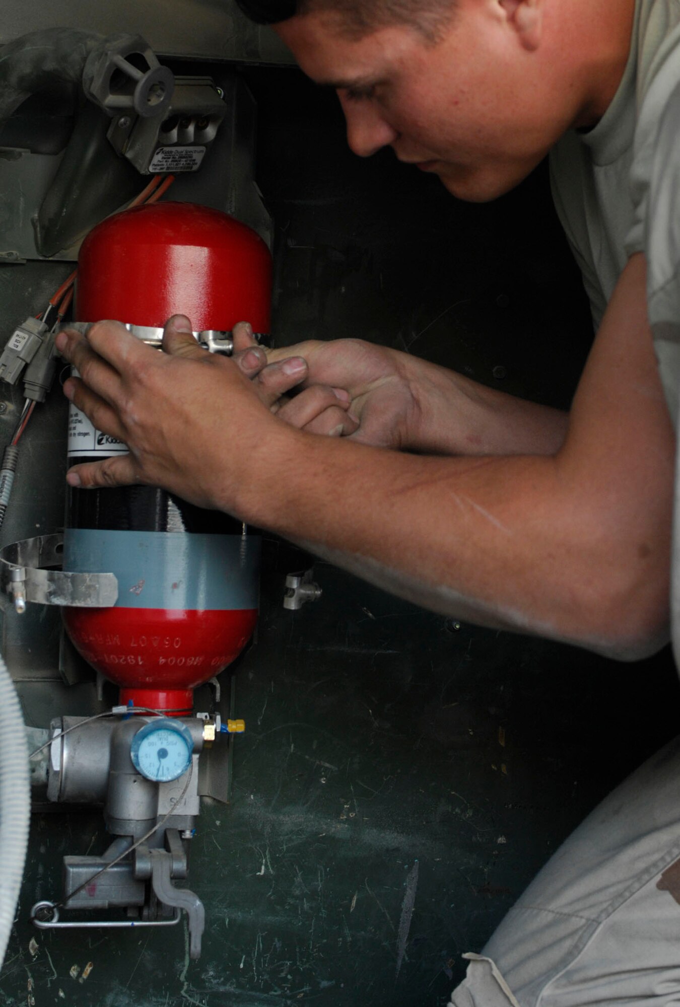 BAGRAM AIR BASE, Afghanistan - Senior Airman Josh Theunissen, a member of Frag Team 5, secures components of a fire suppression system to the inside of an Air Force High Mobility Multipurpose Wheeled Vehicle, Nov. 27, 2007.  Frag Team 5 is responsible for installing up-armor kits, fire suppression systems, improved seat belts, and gunner restraints in Air Force combat vehicles.
(U.S. Air Force photo/Staff Sgt. Joshua T Jasper)  (Released)