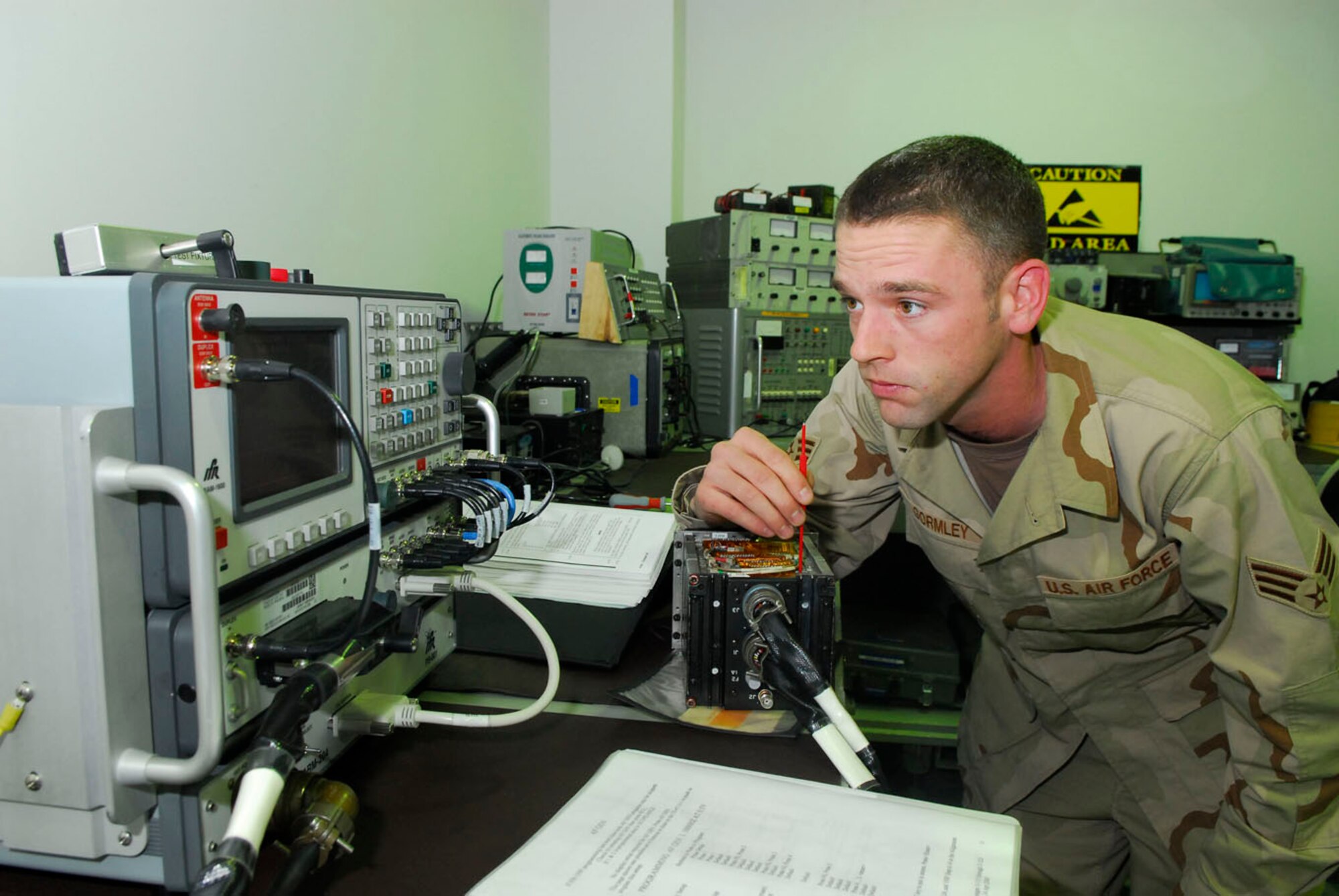 BALAD AIR BASE, Iraq -- Senior Airman Scott Gormley, a 332nd Expeditionary Maintenance Squadron avionics technician, adjusts the output power of an ultra-high frequency radio for an F-16 Fighting Falcon here, Nov. 30. The radio allows pilot to communicate with other pilots and ground personnel. Airman Gormley is deployed from Hill Air Force Base, Utah. (U.S. Air Force Photo/Staff Sgt. Joshua Garcia)