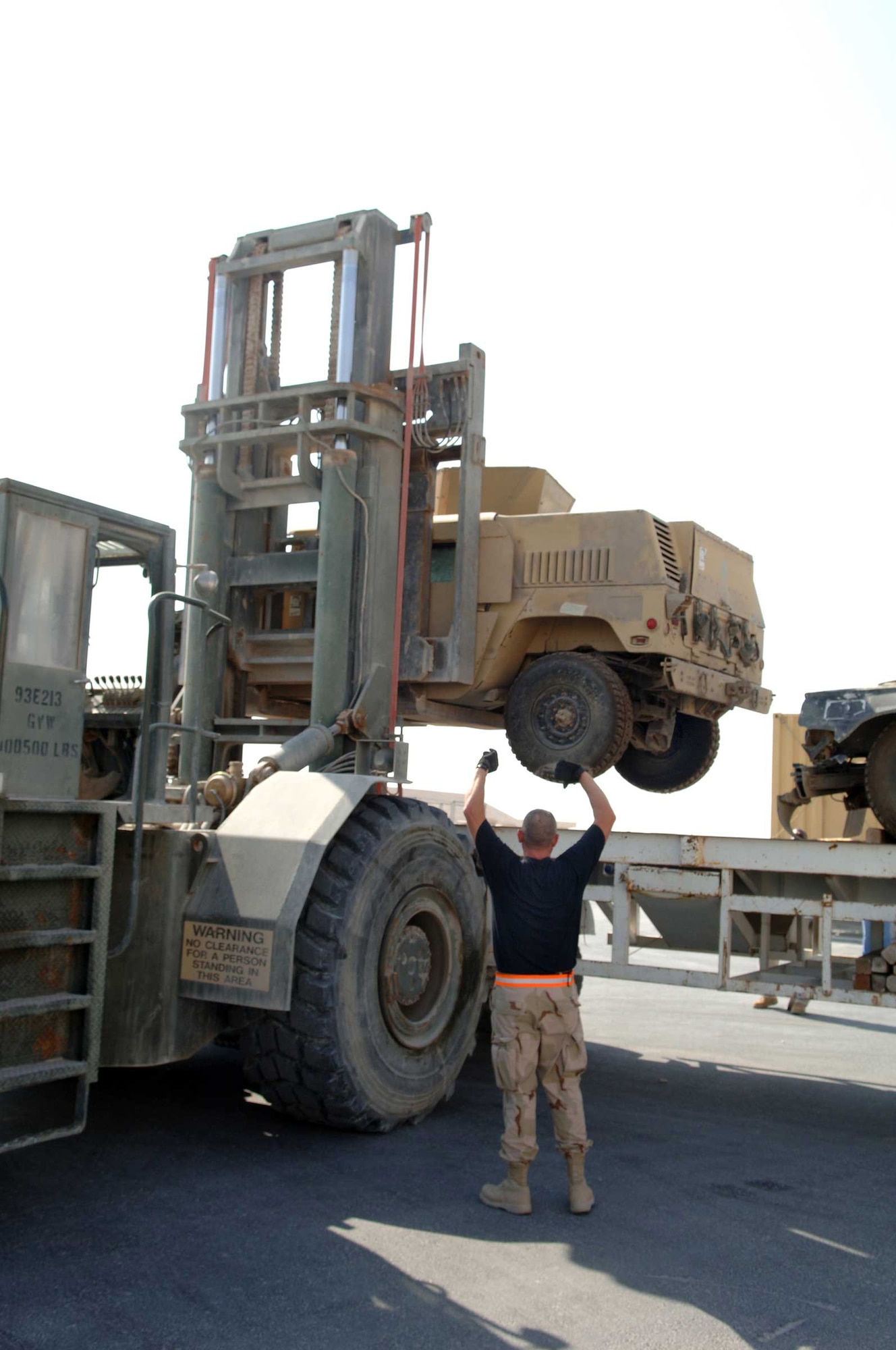 SOUTHWEST ASIA - Master Sgt. Pat Inman directs Tech. Sgt. Norman Haight as he operates a forklift at a base in Southwest Asia. Both sergeants are assigned to the 8th Expeditionary Air Mobility Squadron. Sergeant Inman is from Concordia, Mo., and Sergeant Haight is from Blue Springs, Mo. Both are deployed from the 139th Airlift Wing in Saint Joseph, Mo. (U.S. Air Force photo/Master Sgt. Greg Kunkle)