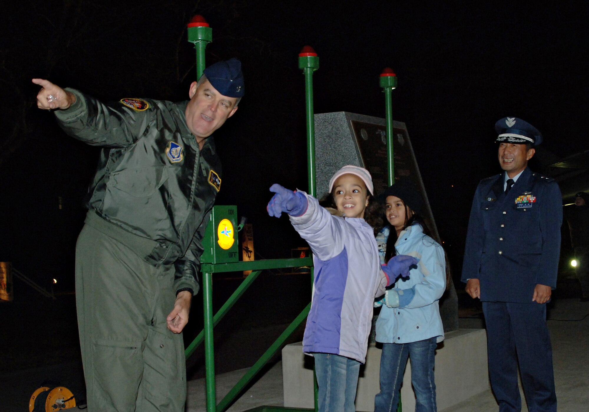 MISAWA AIR BASE, Japan -- Col. Joel Malone, 35th Fighter Wing vice commander, Maj. Gen. Hideo Wakabayashi, 3rd Air Wing commander, and two children from the Misawa schools flip the switches to light up Risner Circle and the water tower during the holiday tree lighting ceremony here Nov. 30. The tree lighting ceremony is an annual event that is attended by Misawa Air Base residents. (U.S. Air Force photo by Airman 1st Class Benjamin Wilson)