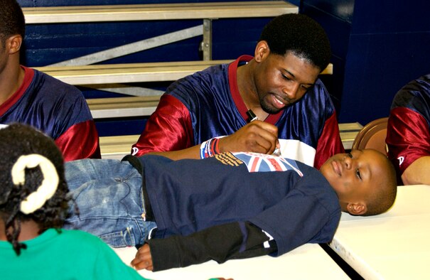 Christian Miley, 7, gets his shirt signed by LeRon Bradley from the Harlem Ambassadors after an exhibition game between the Ambassadors and the Misawa Jets at the Potter Fitness Center Nov. 28. The Ambassadors promotes staying in school, staying drug-free and fostering racial harmony. (U.S. Air Force photo by Airman 1st Class Eric Harris)